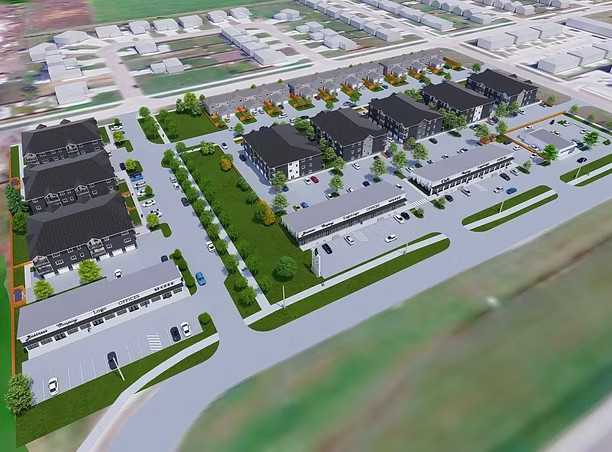 Aerial view of a residential complex with modern townhouses, parking spaces, and landscaped green areas, surrounded by suburban neighborhood.