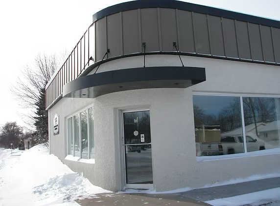 Exterior view of a commercial law office building with snow on the ground and a glass entrance door.