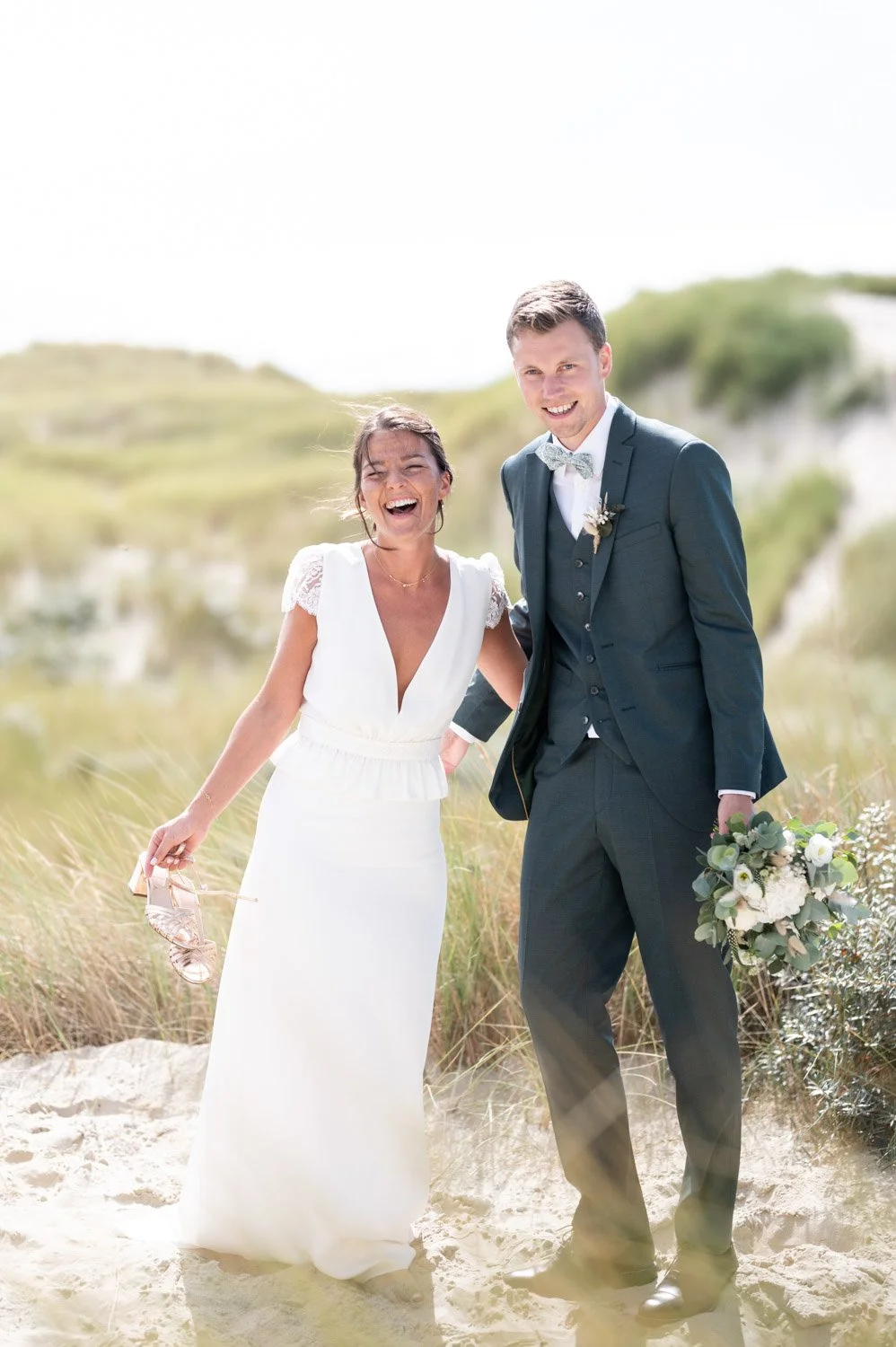 Couple de mariés dans les dunes du Touquet, heureux pendant une belle journée d'été