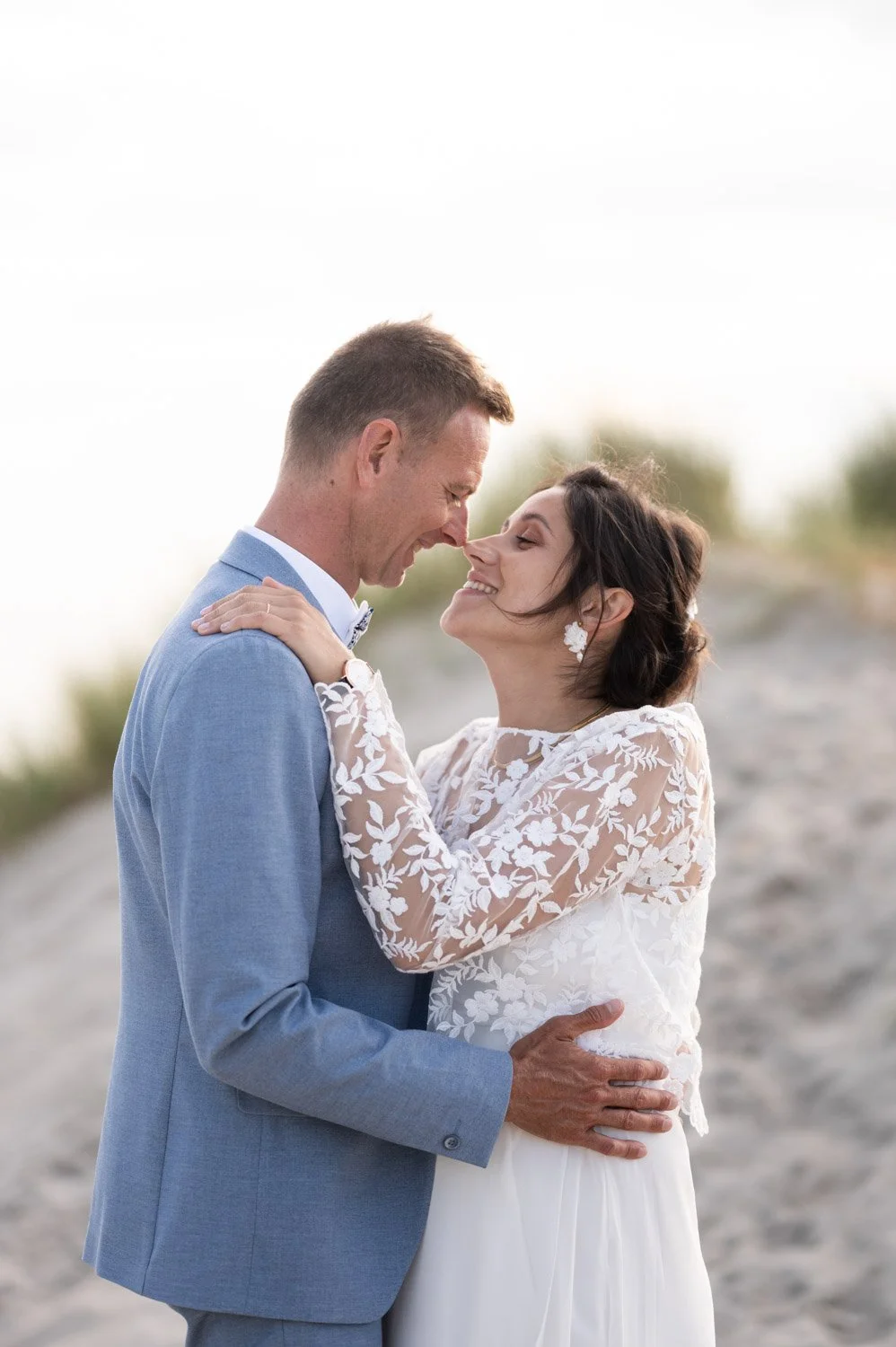 Couple de mariés qui s'embrasse dans les dunes de Stella Plage en fin de journée