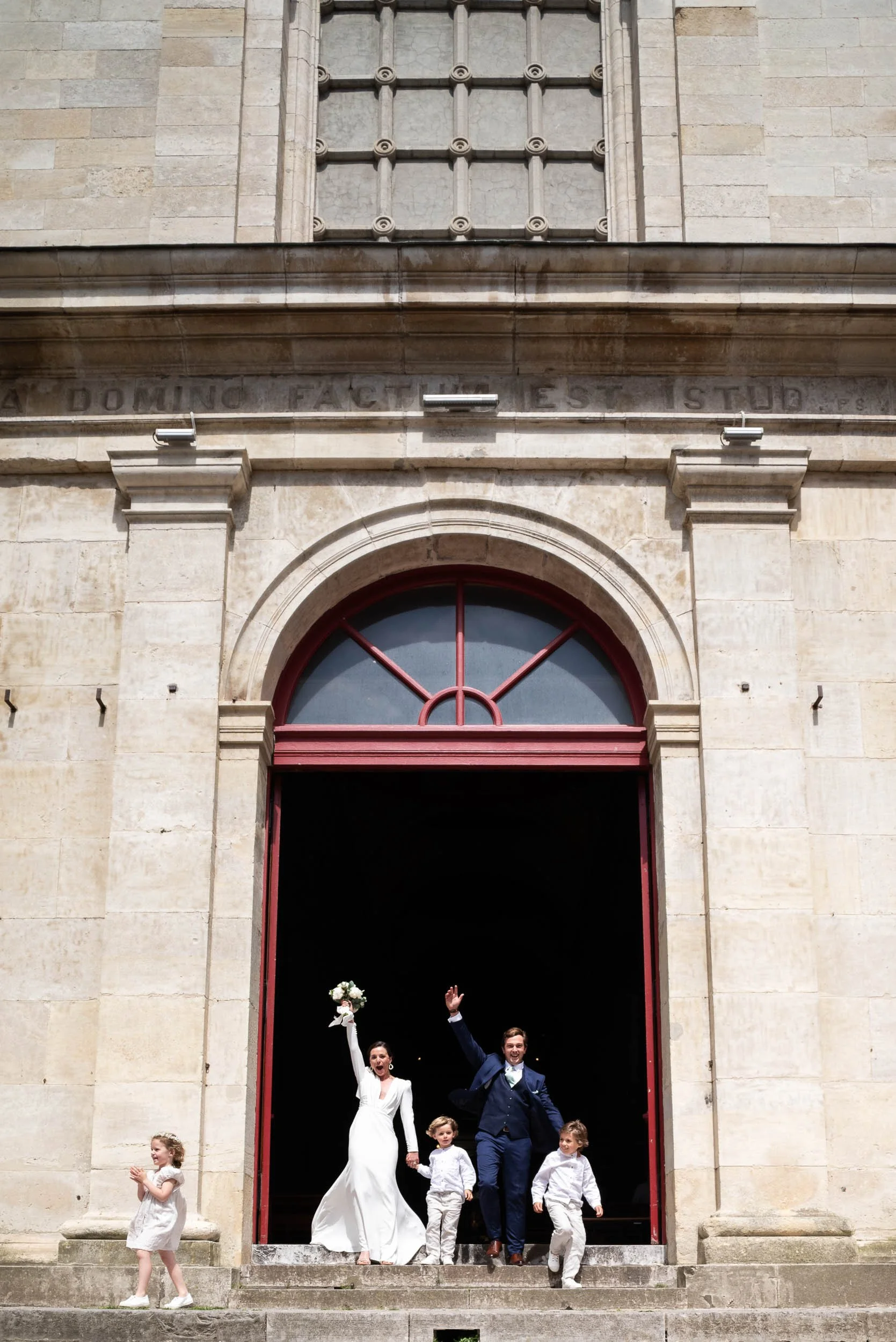 Sortie de la Basile Notre Dame de Boulogne sur mer des mariés qui exprime leur joie en criant et en levant les bras. Ils sont avec leurs enfants