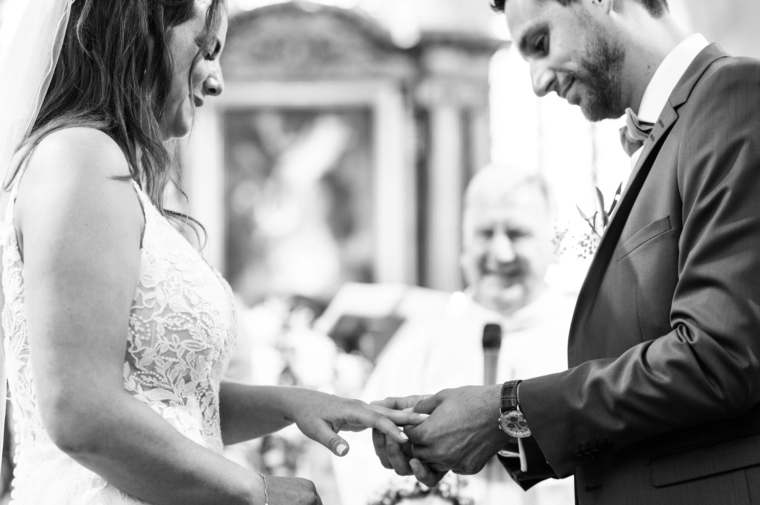 échanges des alliances entre les mariés en noir et blanc à l'eglise de Marquise
