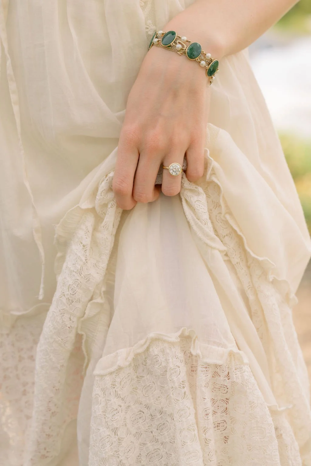 Bride holding her dress with her wedding band showing