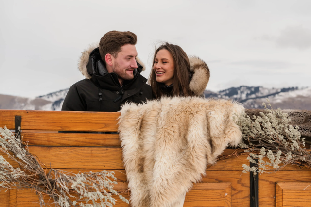 Couple in a sleigh after proposal at Vintage Adventures in Jackson Hole