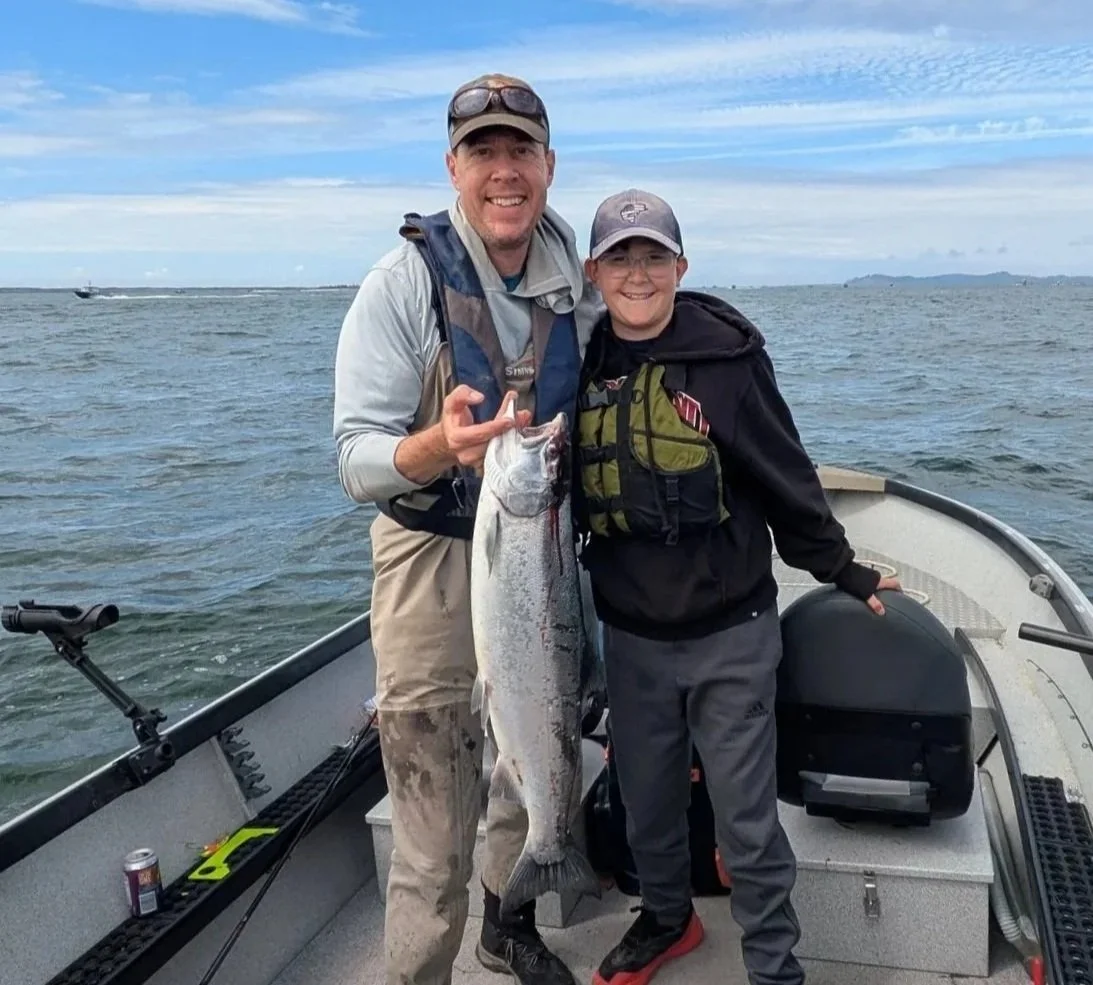 Anglers holding a Chinook salmon caught on the Columbia River with FLOODTIDE Angling