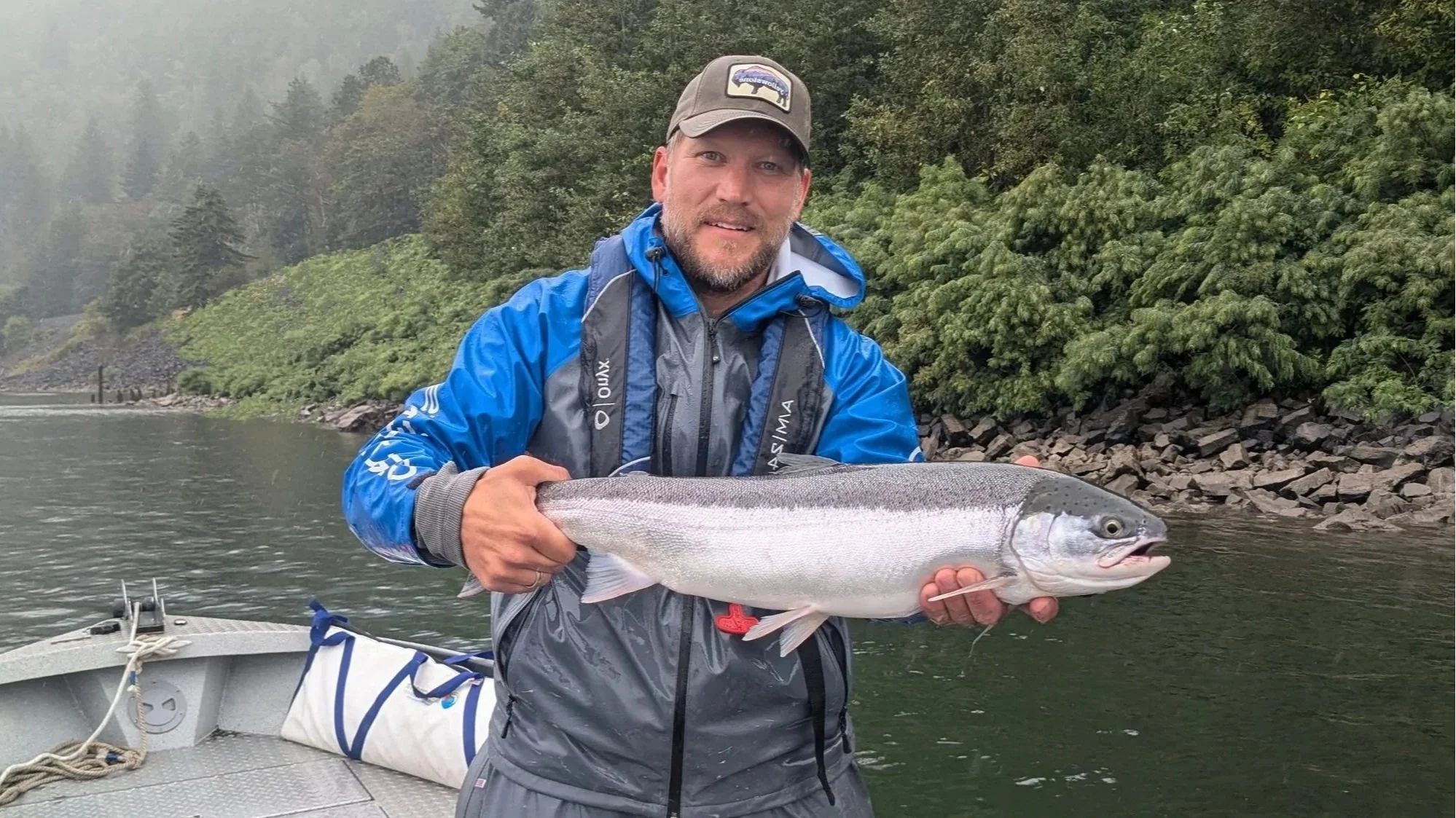 Angler holding a bright summer steelhead from the Columbia River.