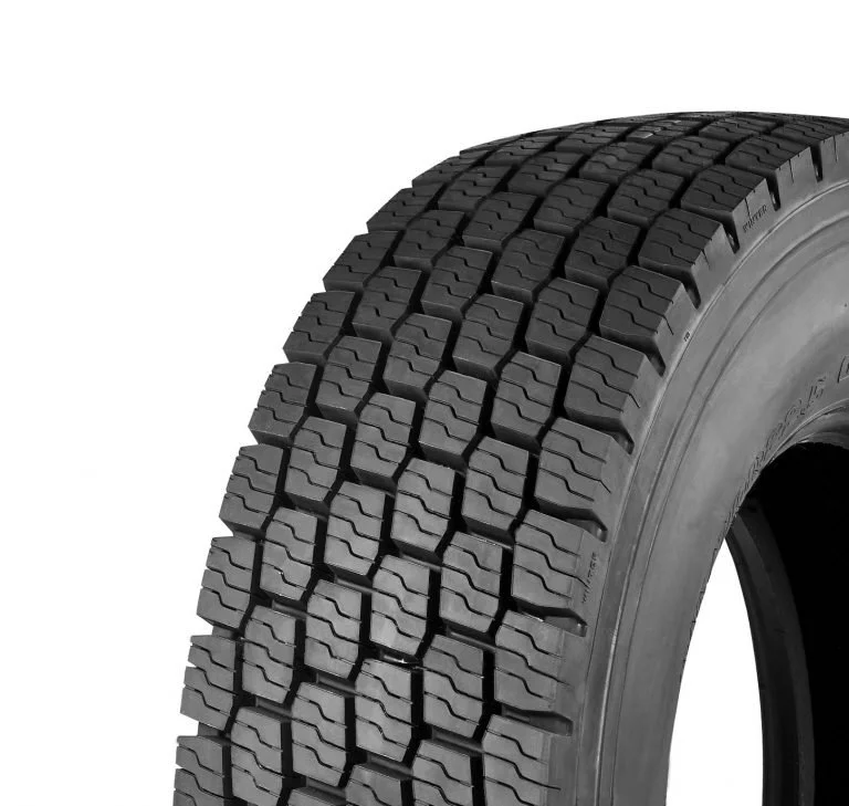 Close-up of a black tire with detailed tread pattern on a white background.