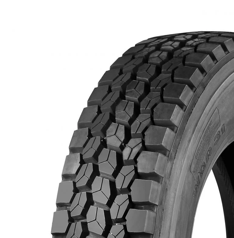 Close-up of a black rubber tire showing deep tread pattern with large, interlocking geometric shapes.