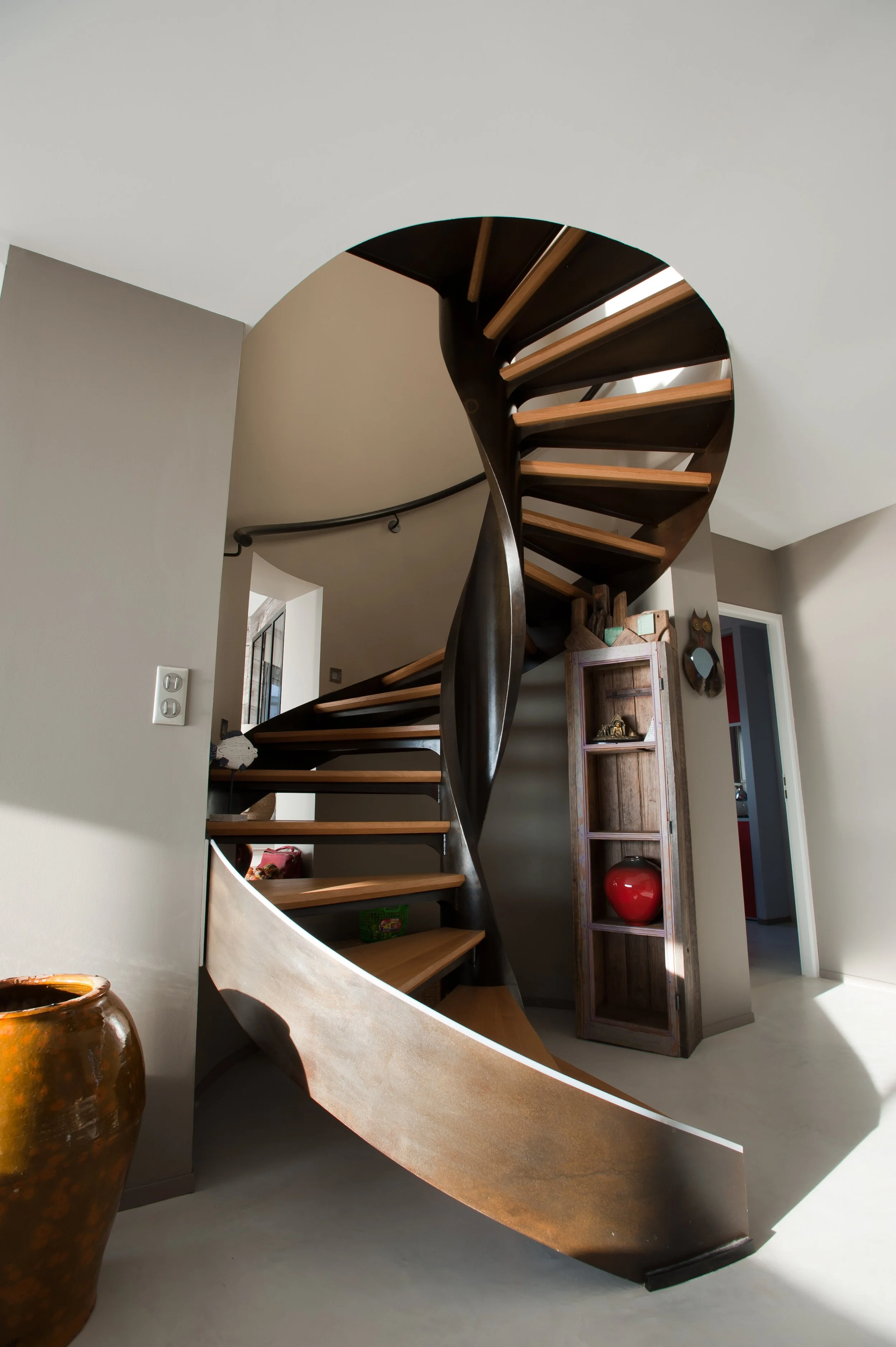Escalier en spirale en bois et métal dans une maison contemporaine.