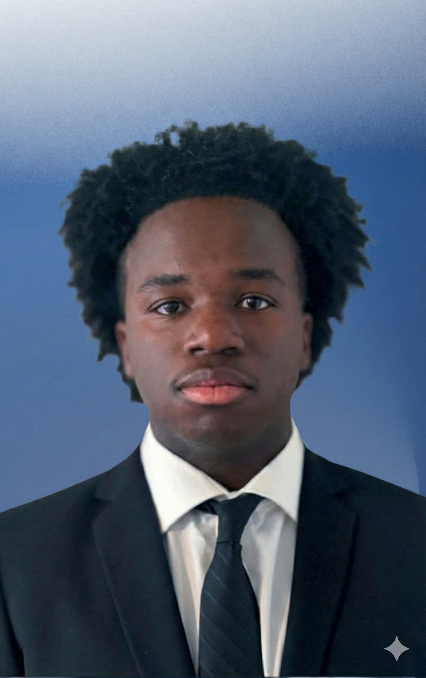 Portrait of a young Black man in formal attire, wearing a suit and tie, with a blurred blue background.