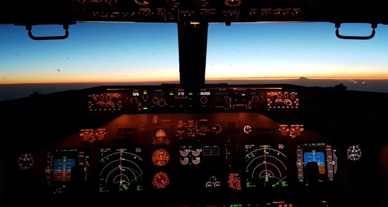 AirOps Vector — airline cockpit view at sunset, symbolizing pilot evaluations, safety reviews, and aircraft ferry flight expertise.