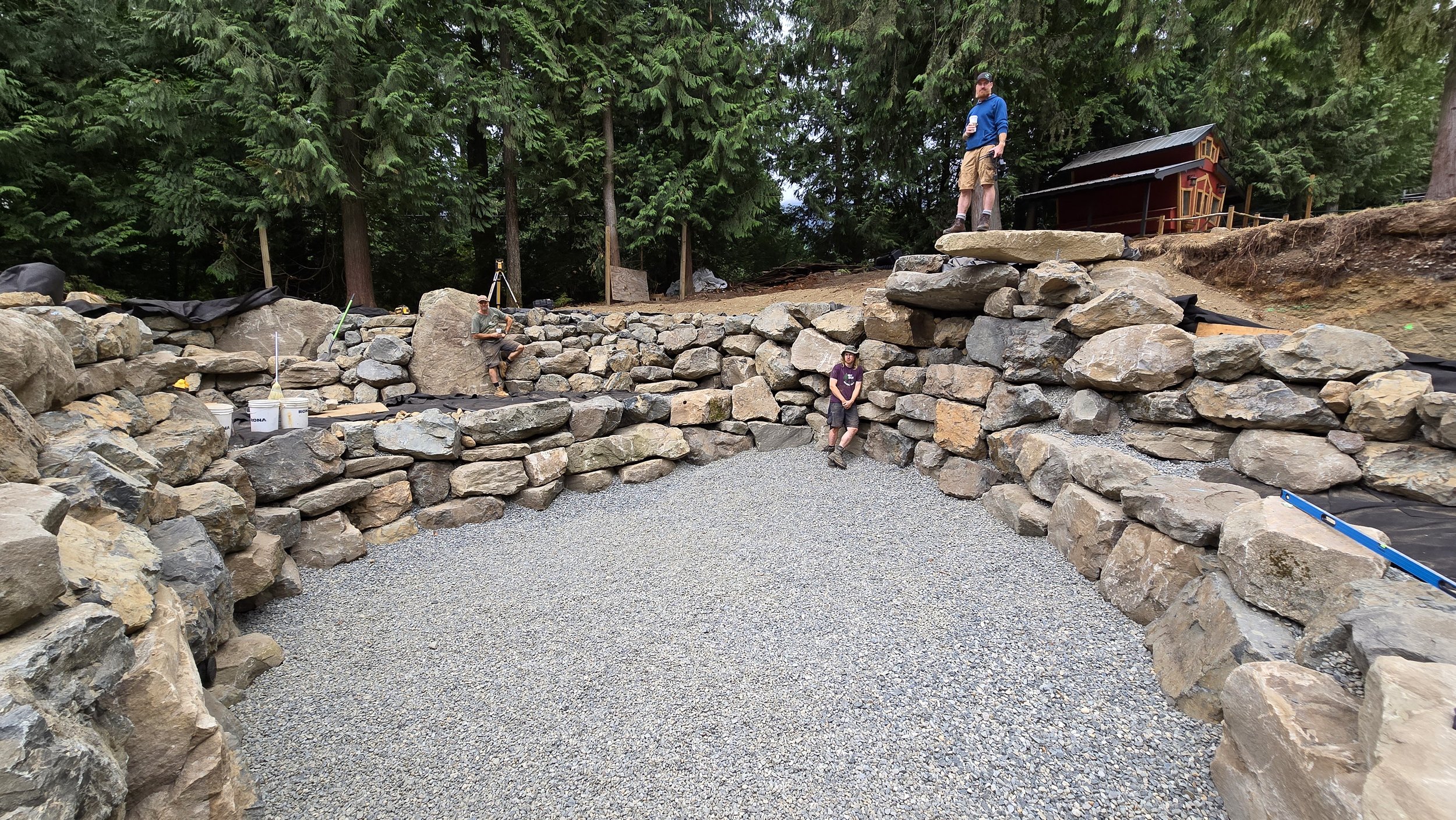 Custom natural pool with boulder retaining wall and aggregate bottom prior to filling
