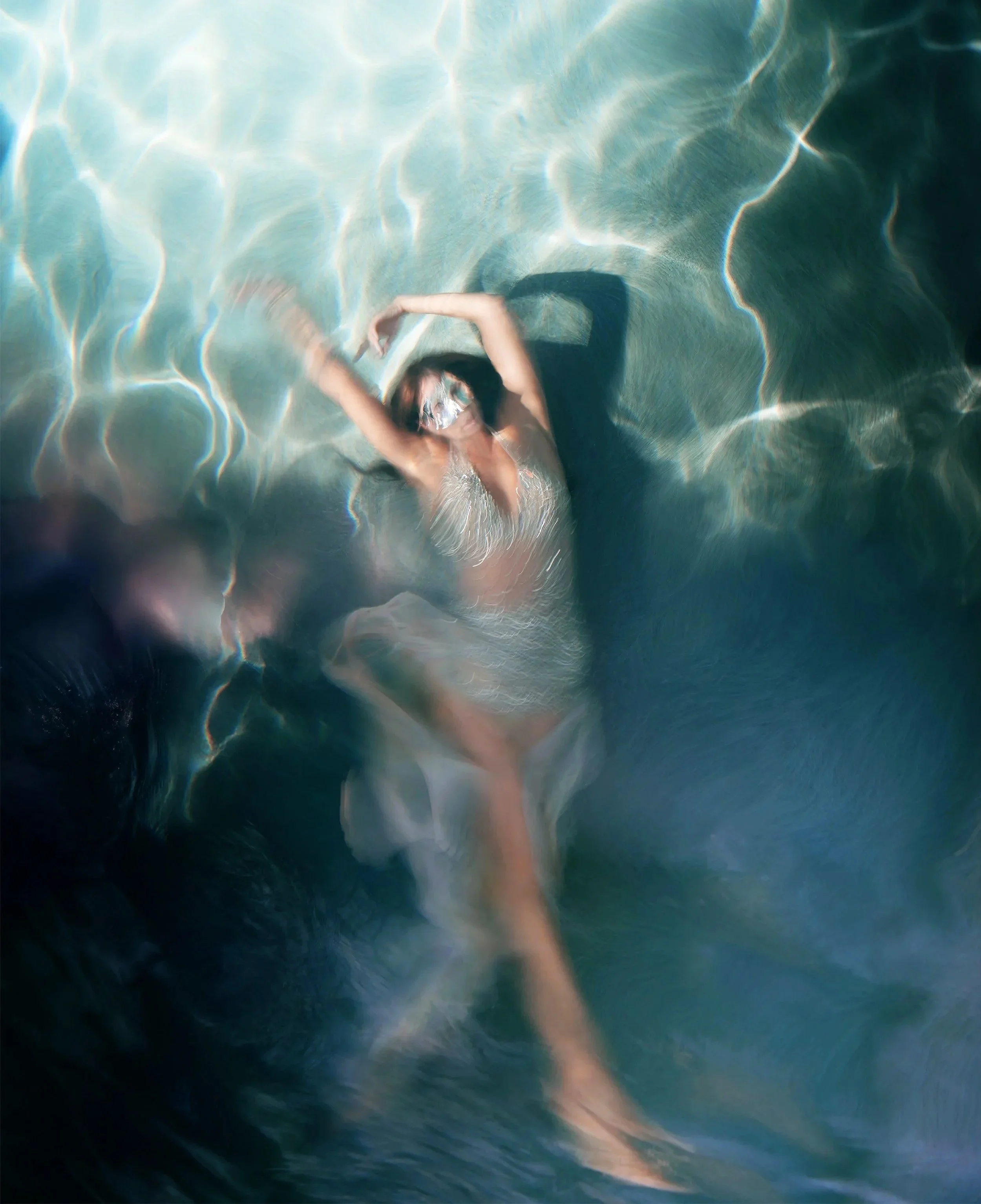 A woman in a swimsuit wearing sunglasses, floating in a swimming pool, captured from above.