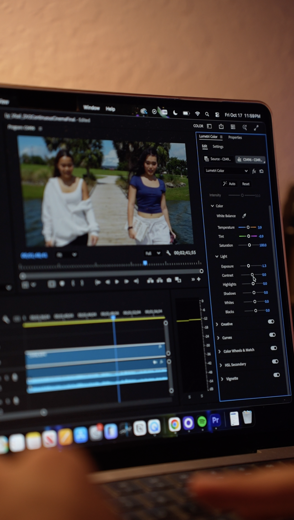 Computer screen displaying a video editing software with a blurry photo of two women walking outdoors by a body of water.