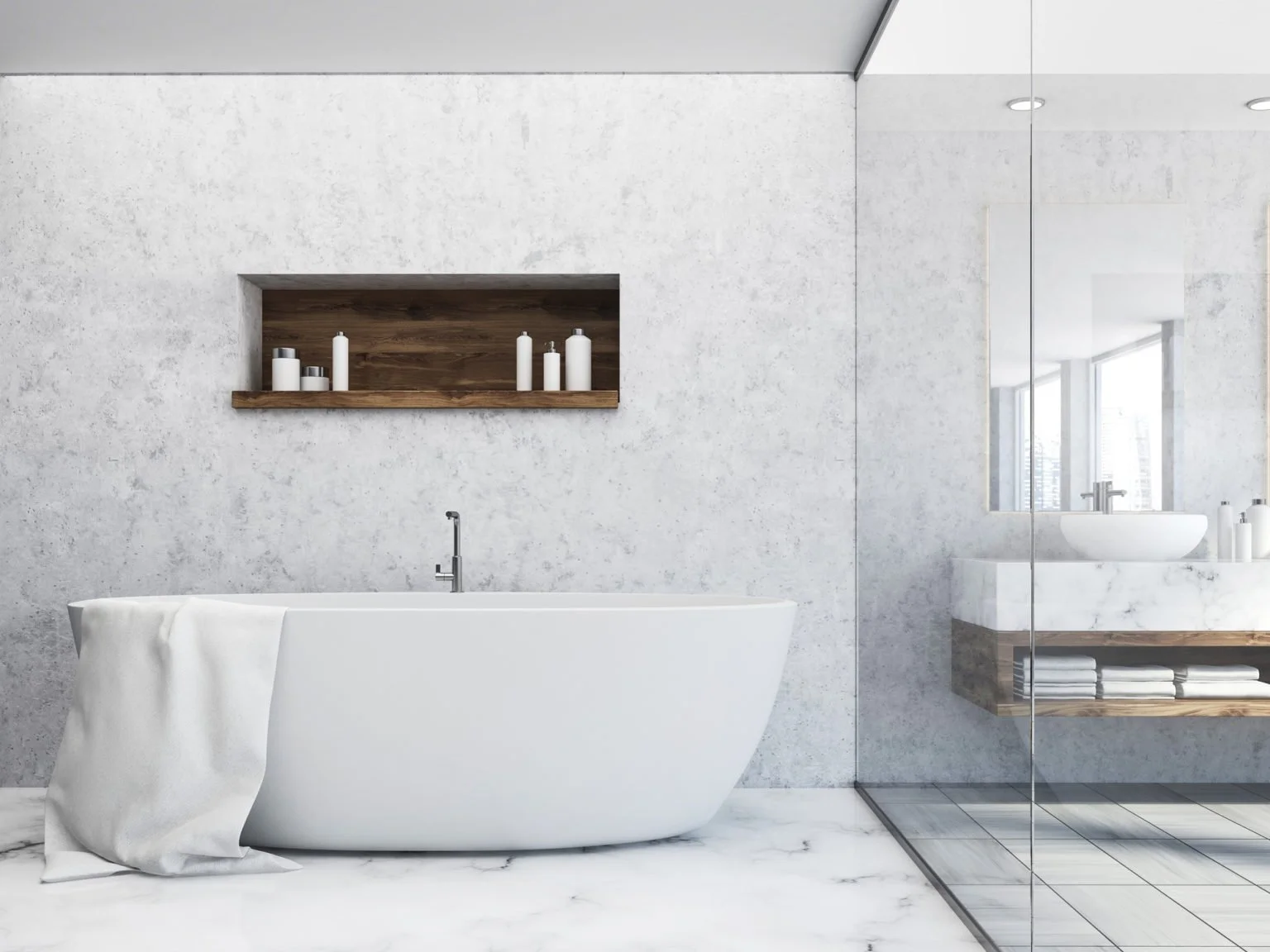 Modern bathroom with white freestanding bathtub, wooden shelf with candles, marble floor, and a glass-enclosed shower area with a white vessel sink and large window.