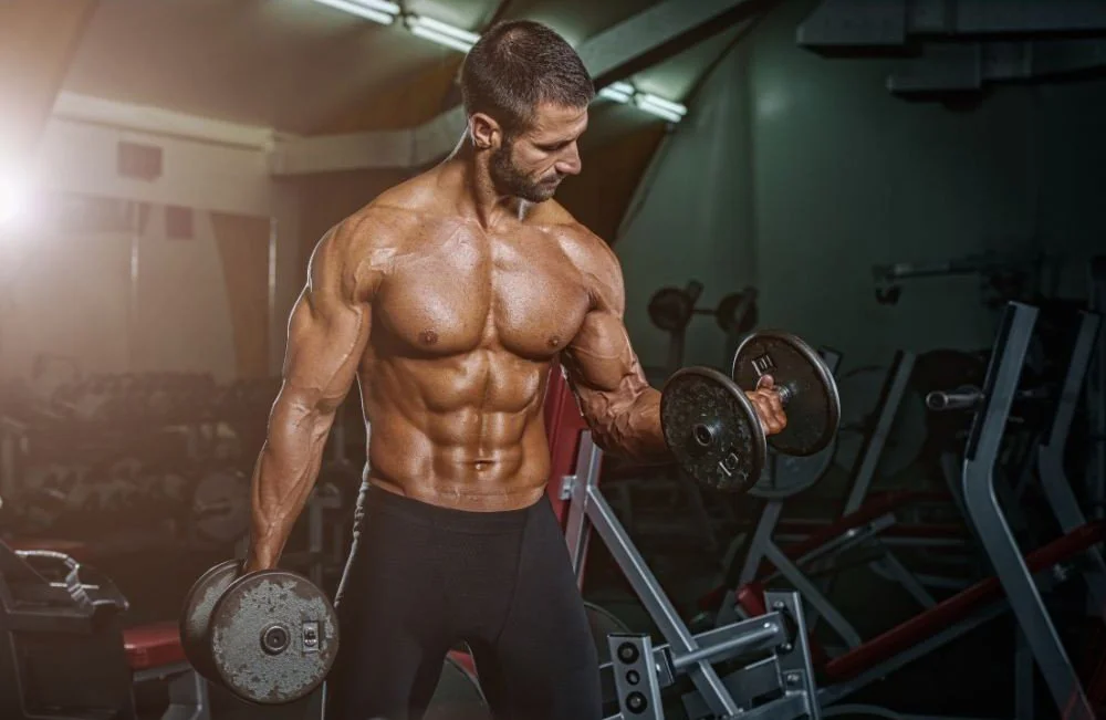 Image of a shirtless fit guy curling weights