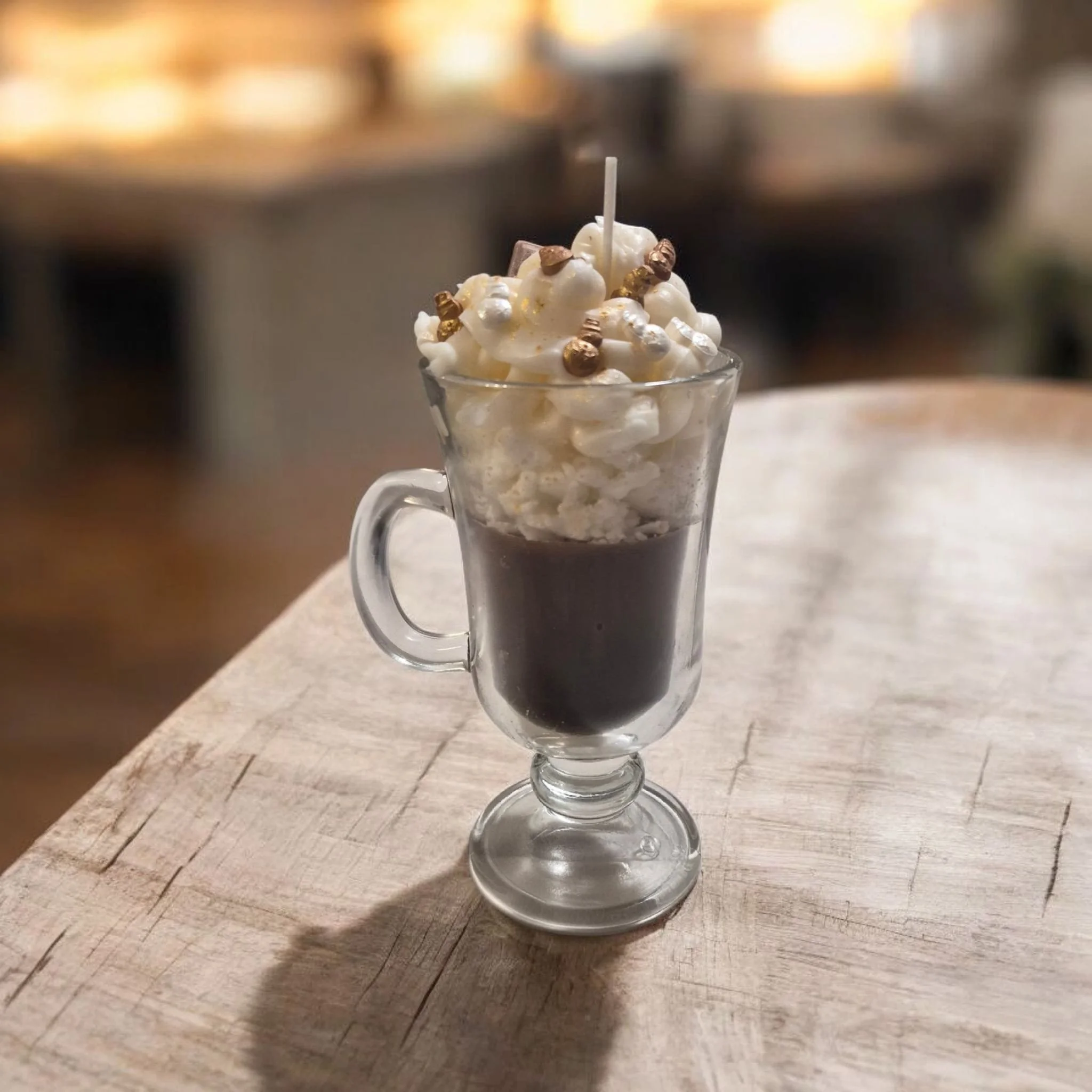 Ein Glas mit heißem Kaffee, garniert mit Schlagsahne und essbarem Gold