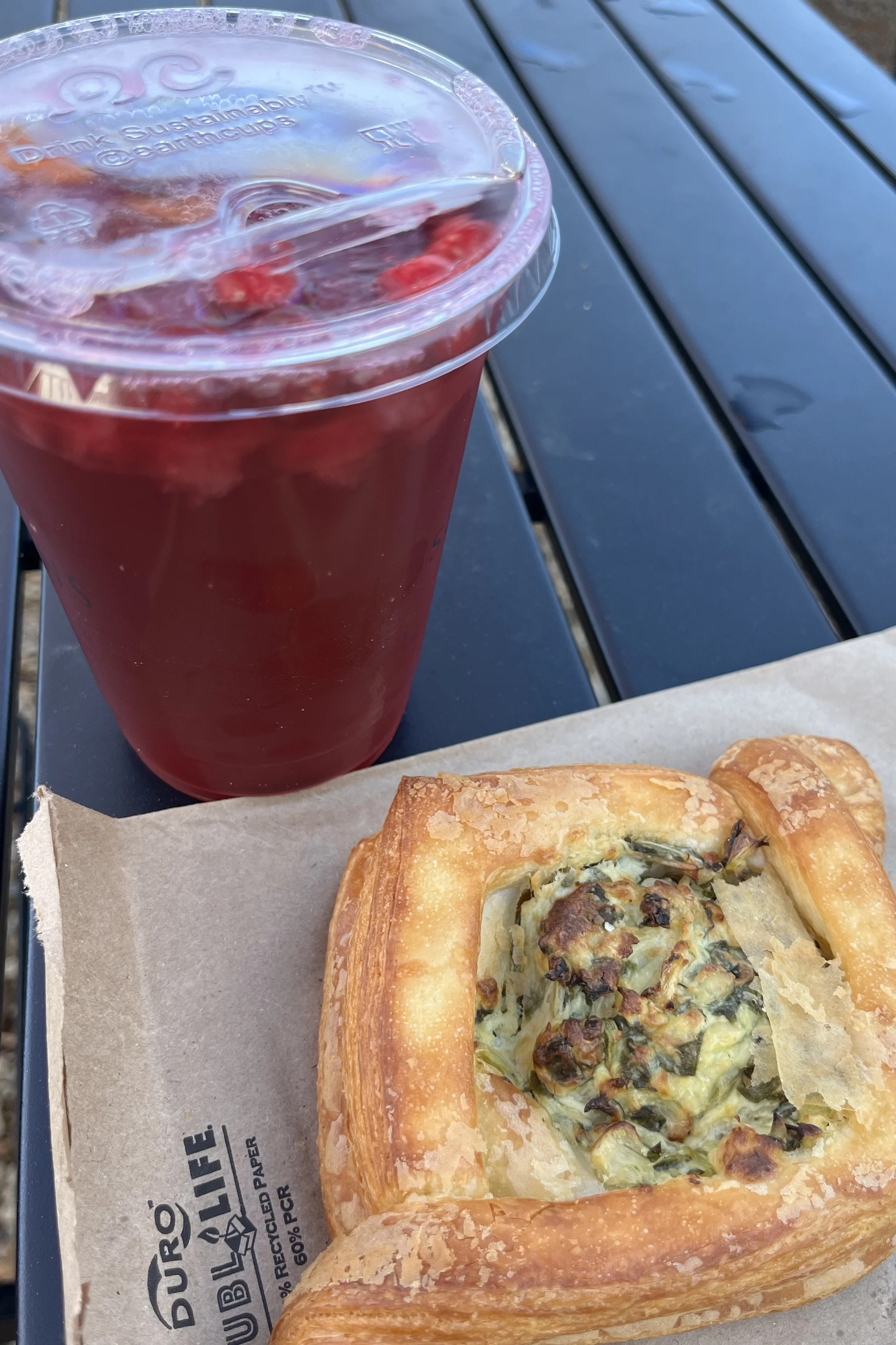 Savory pastry and sparkling cranberry soda on an outdoor table at Seasons’ Yield Café in Lexington.
