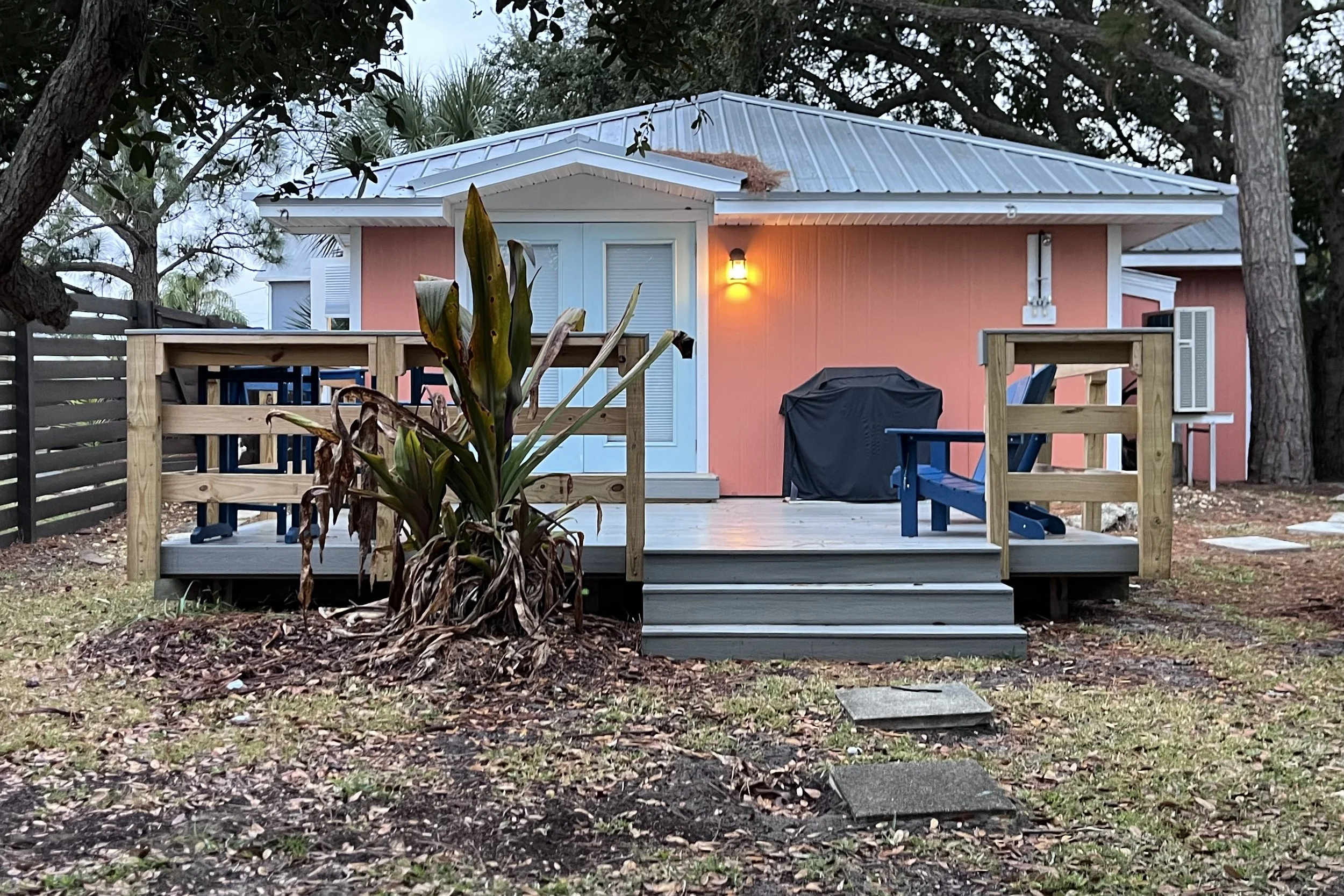 Pink cottage with a small deck and fenced yard near Butler Beach, Florida, suitable for dog-friendly travel.