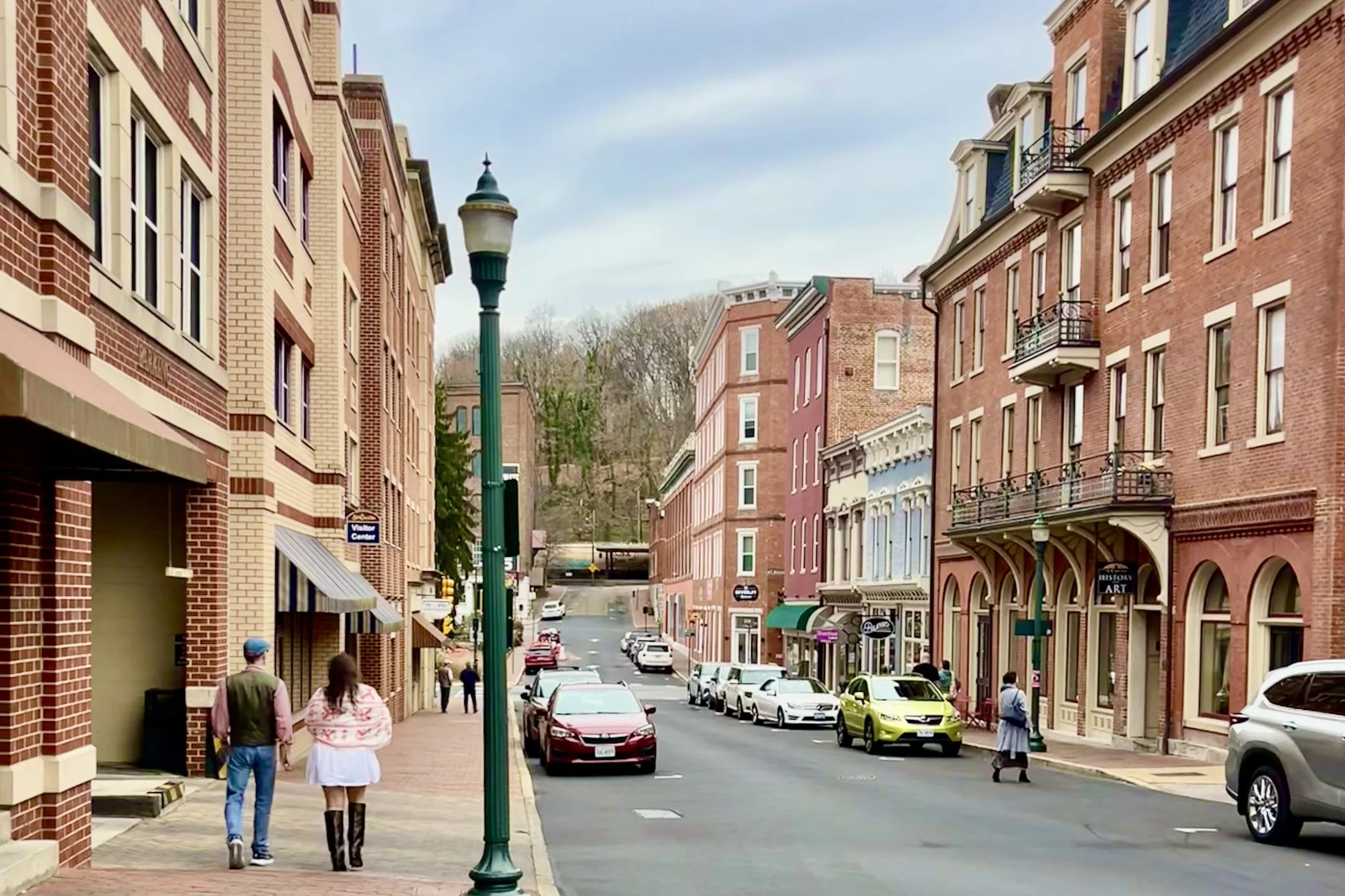 Historic downtown street in Staunton, Virginia with brick buildings, storefronts, and a walkable main street under a clear blue sky.