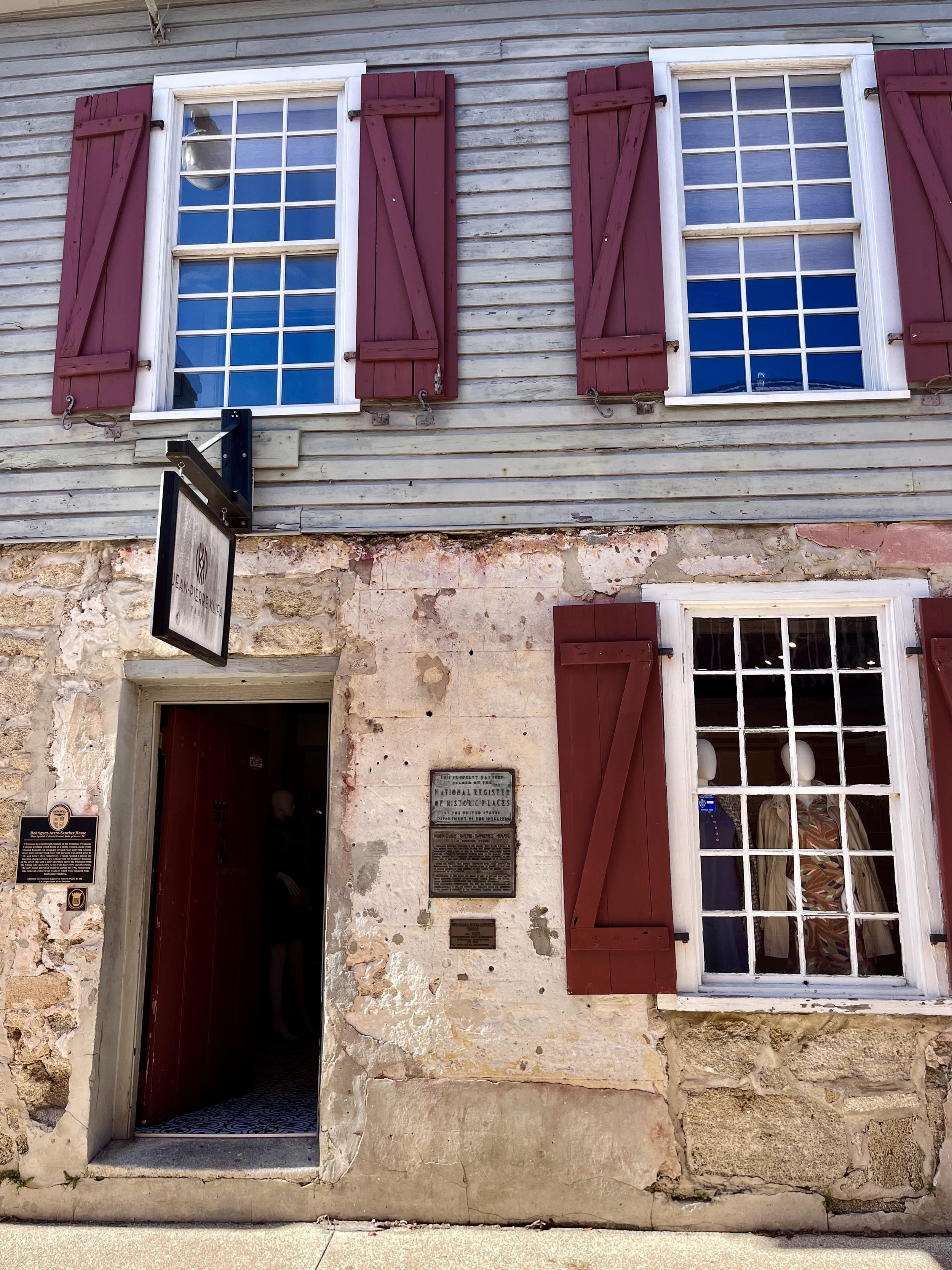Historic stone building facade with red shutters in Old Town St. Augustine