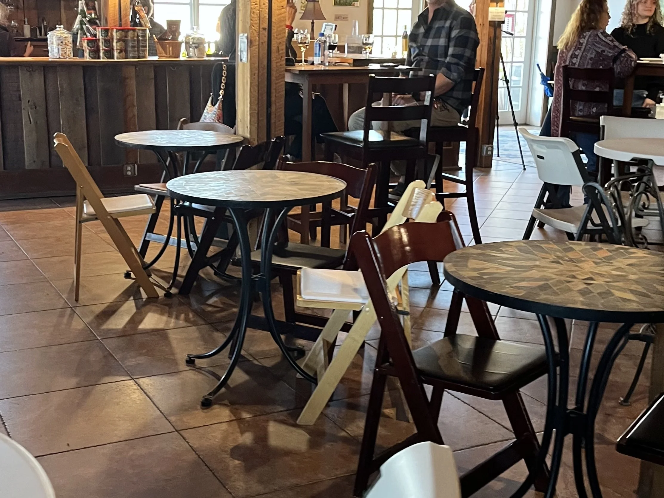 Indoor dog-friendly brewery with closely spaced tables and dogs positioned near each other.