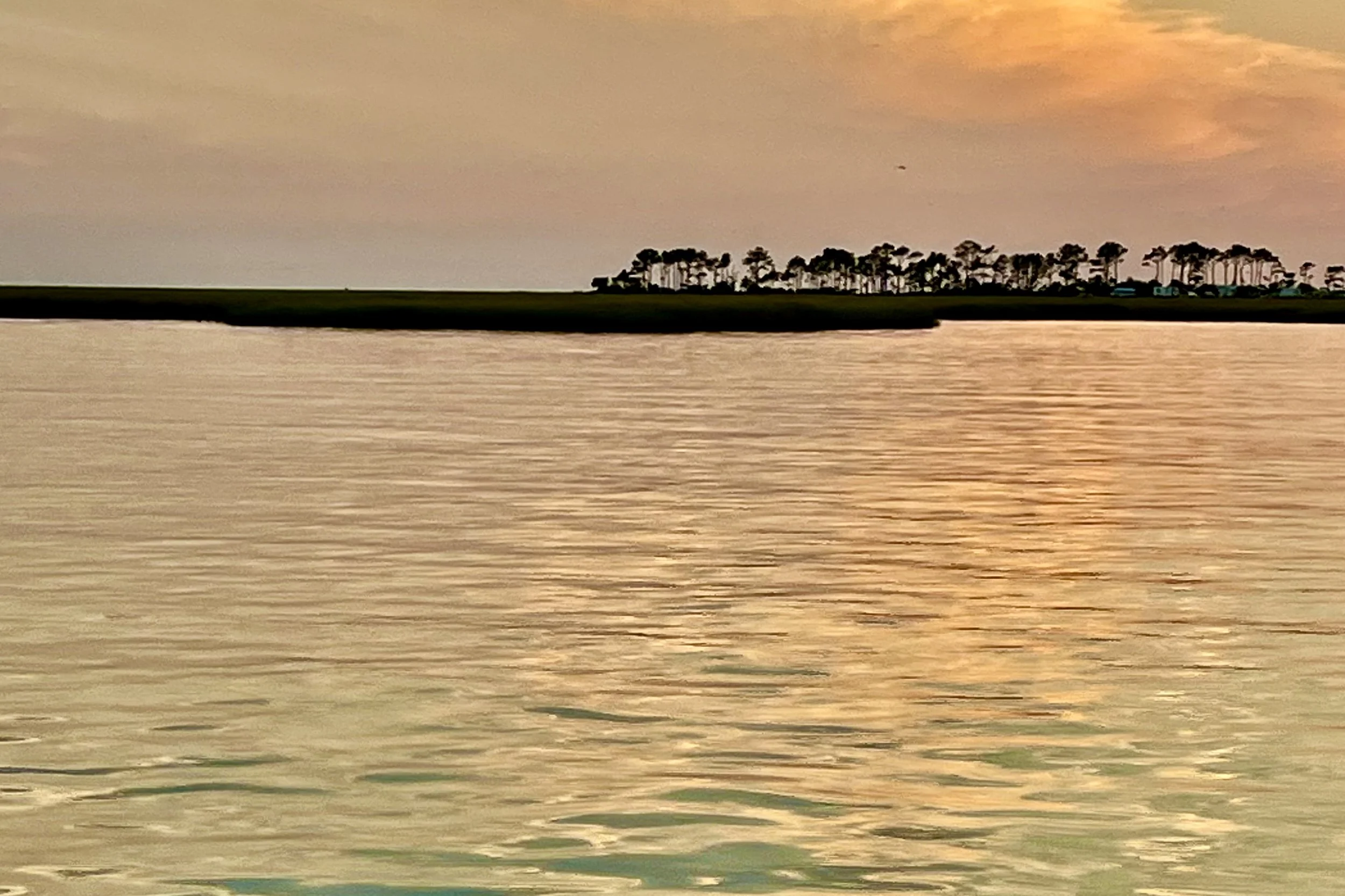 Wide sunset view over calm water in Cape Charles, Virginia, showing expansive shoreline and open horizon.