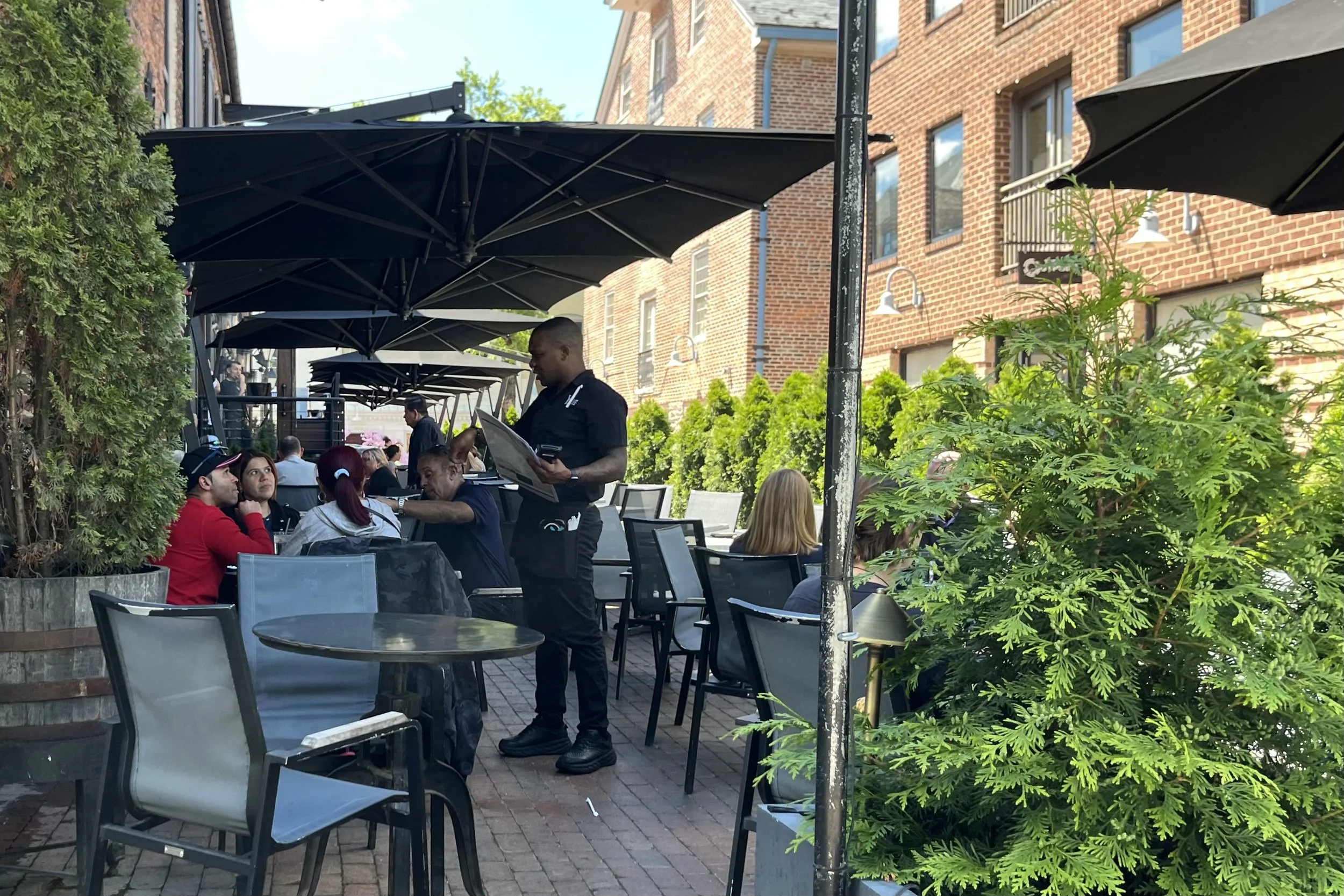Dog-friendly patio seating at Virtue Feed & Grain in Old Town Alexandria with brick surroundings and outdoor tables along Wales Alley.