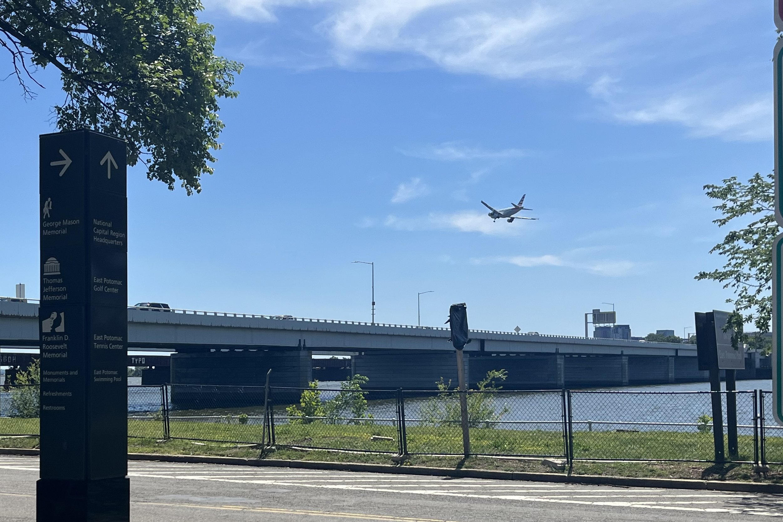 Airplane flying low overhead near Hains Point in Washington, DC, beside the waterfront and East Potomac Park walking area.