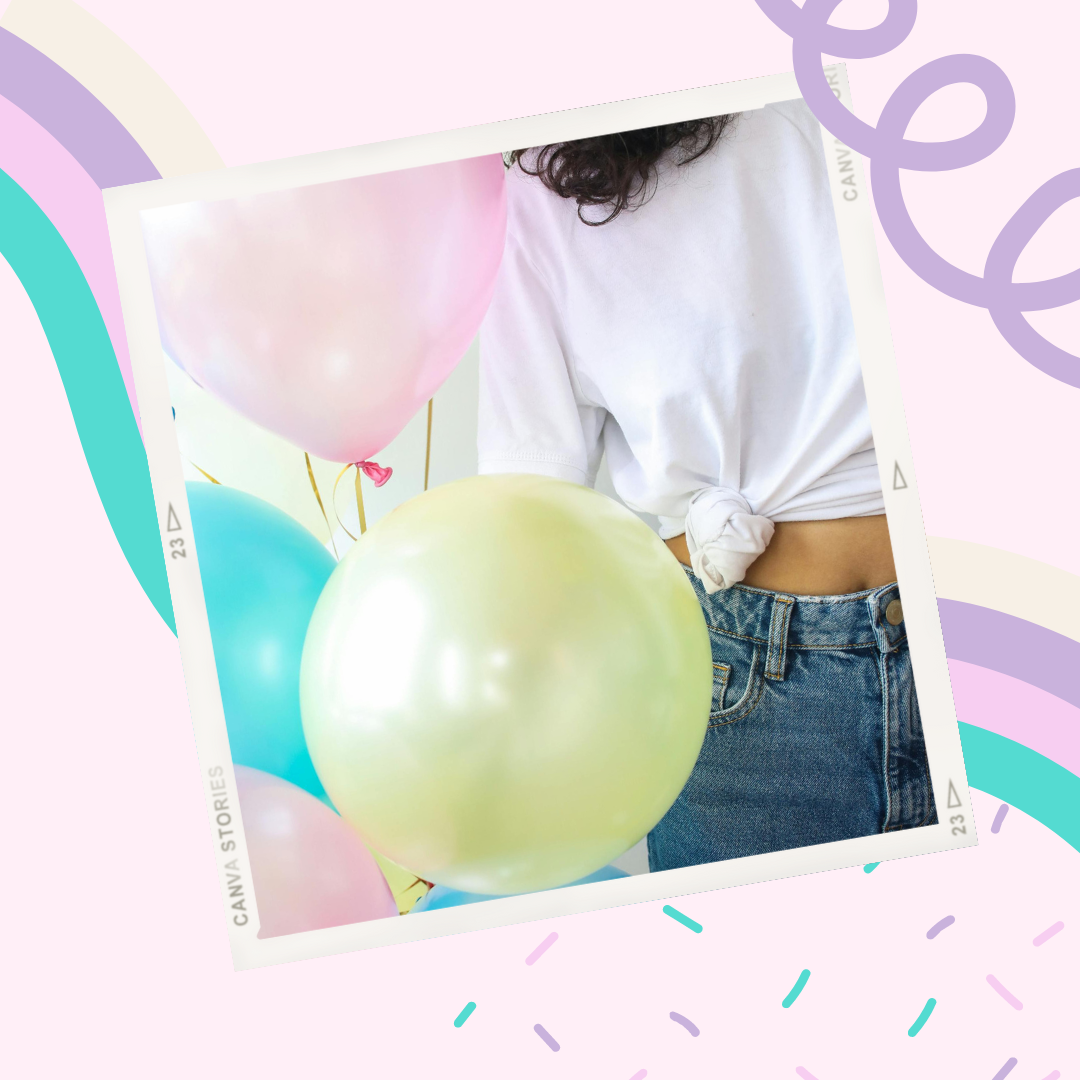 Partial view of a person wearing a white t-shirt tied in a knot, with curly dark hair, surrounded by pastel-colored balloons.