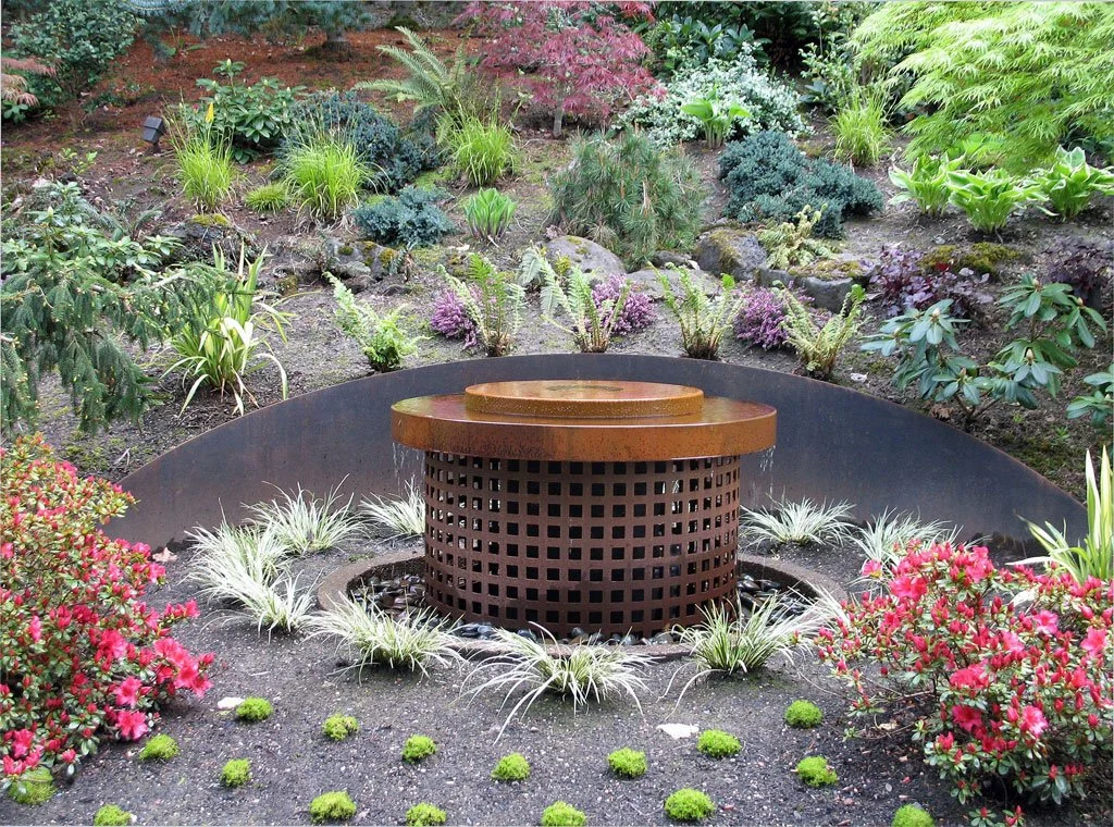 "Perf" steel fountain. 48" diameter x 40"h with steel retaining wall