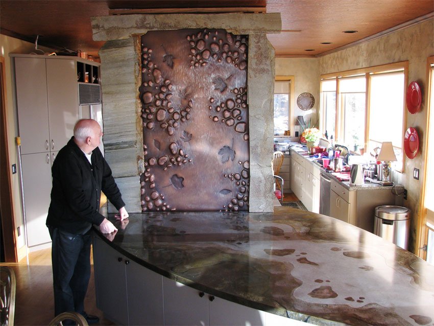 "Fall Stream" water feature. Micro-hammered copper with natural stone surround. Patinated metal countertop with stream theme