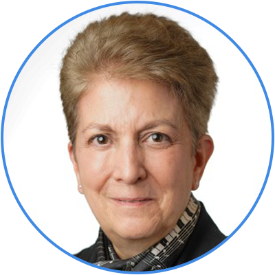 Portrait of an older woman with short gray hair, wearing a black blazer and patterned shirt, smiling slightly.