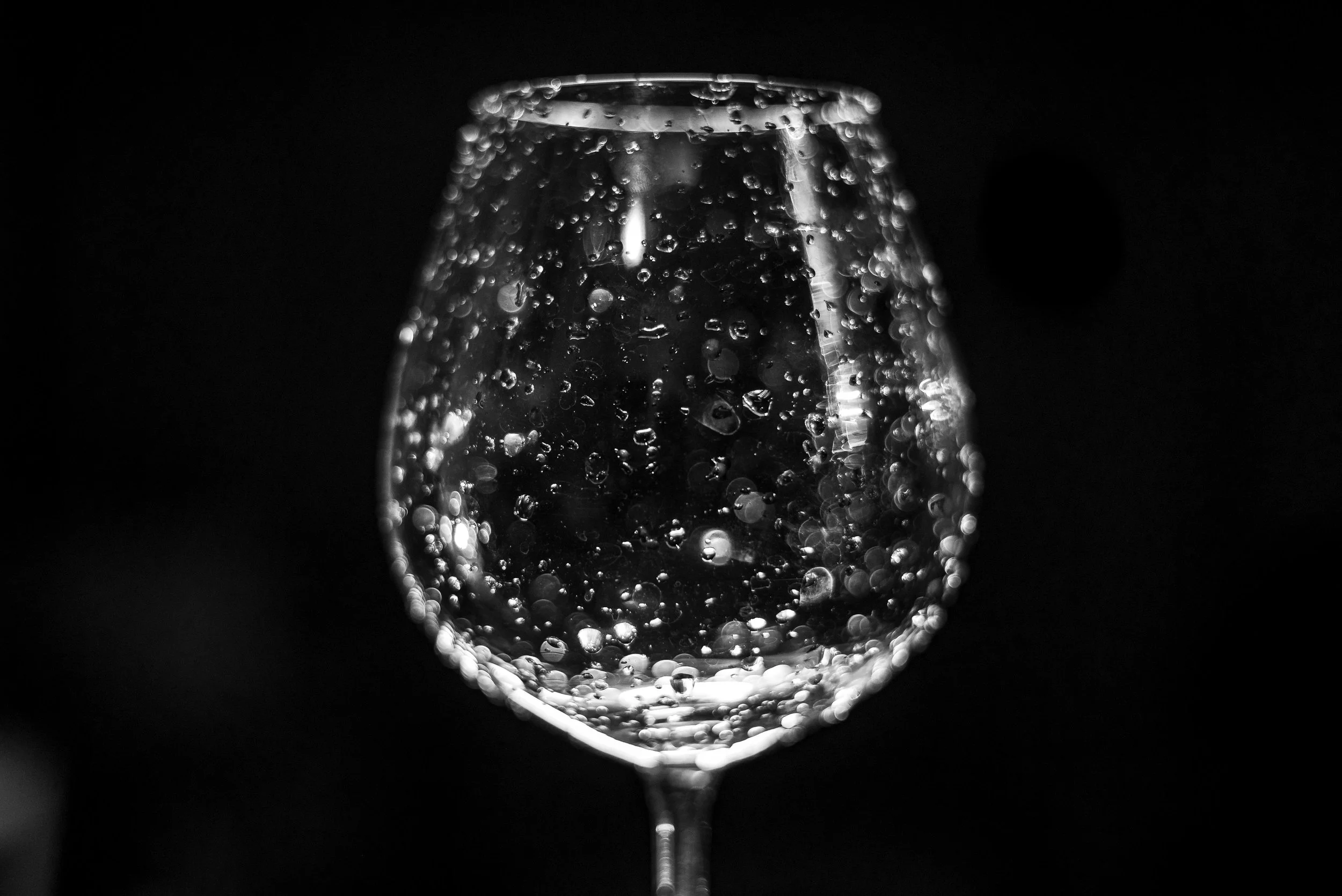 Copa de vino espumoso con burbujas, en estilo en blanco y negro.