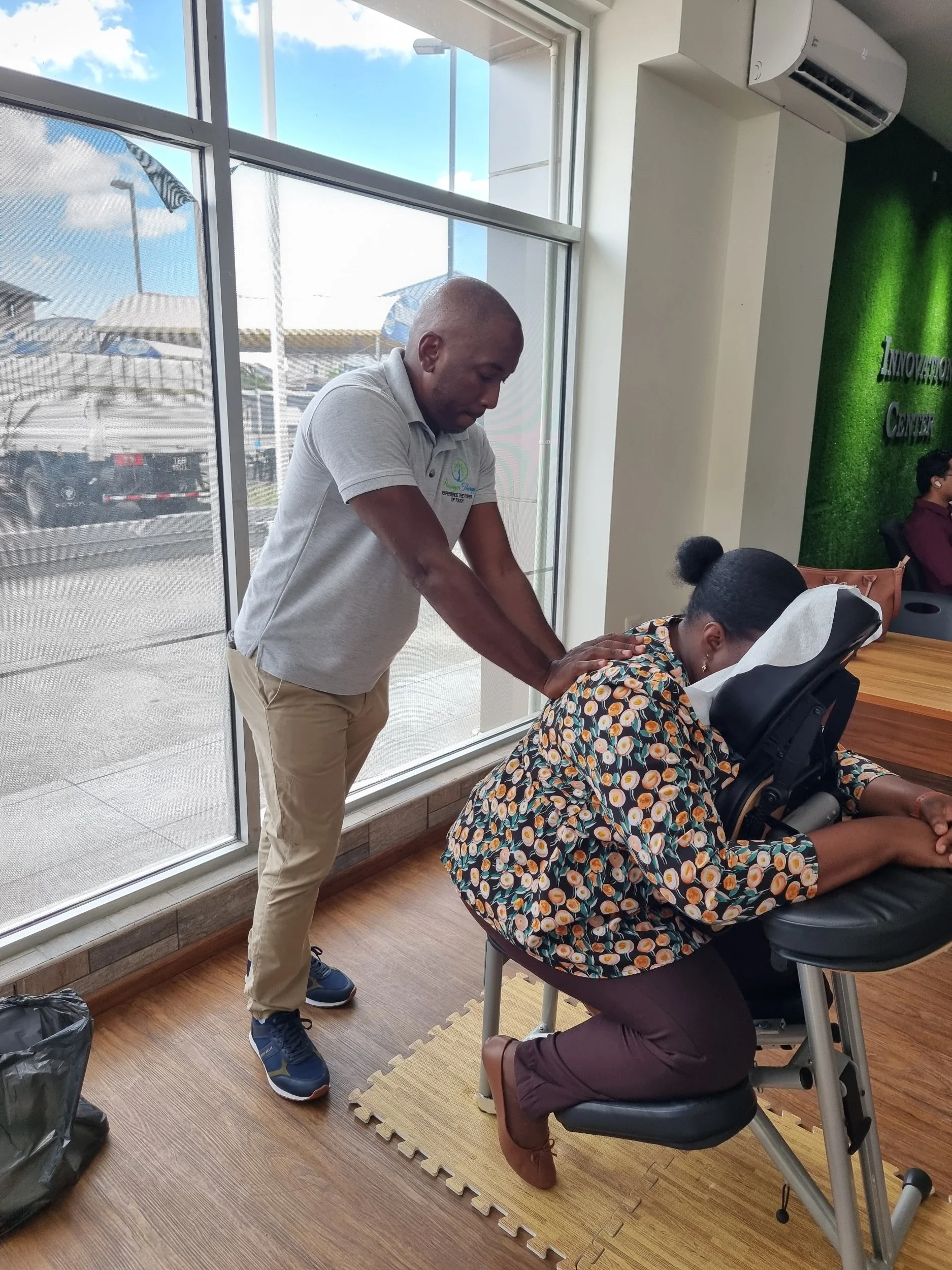 Talon Thomas providing on-site chair massage at a workplace event.