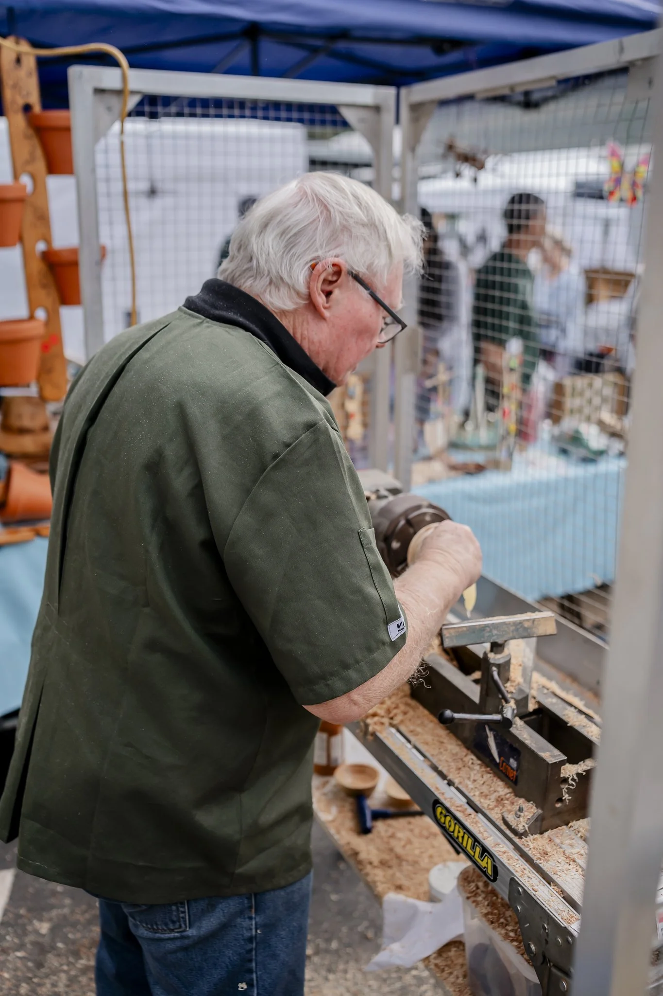 Woodworking at a workbench with wood shavings, at the Oyster Bay Art and Craft Festival