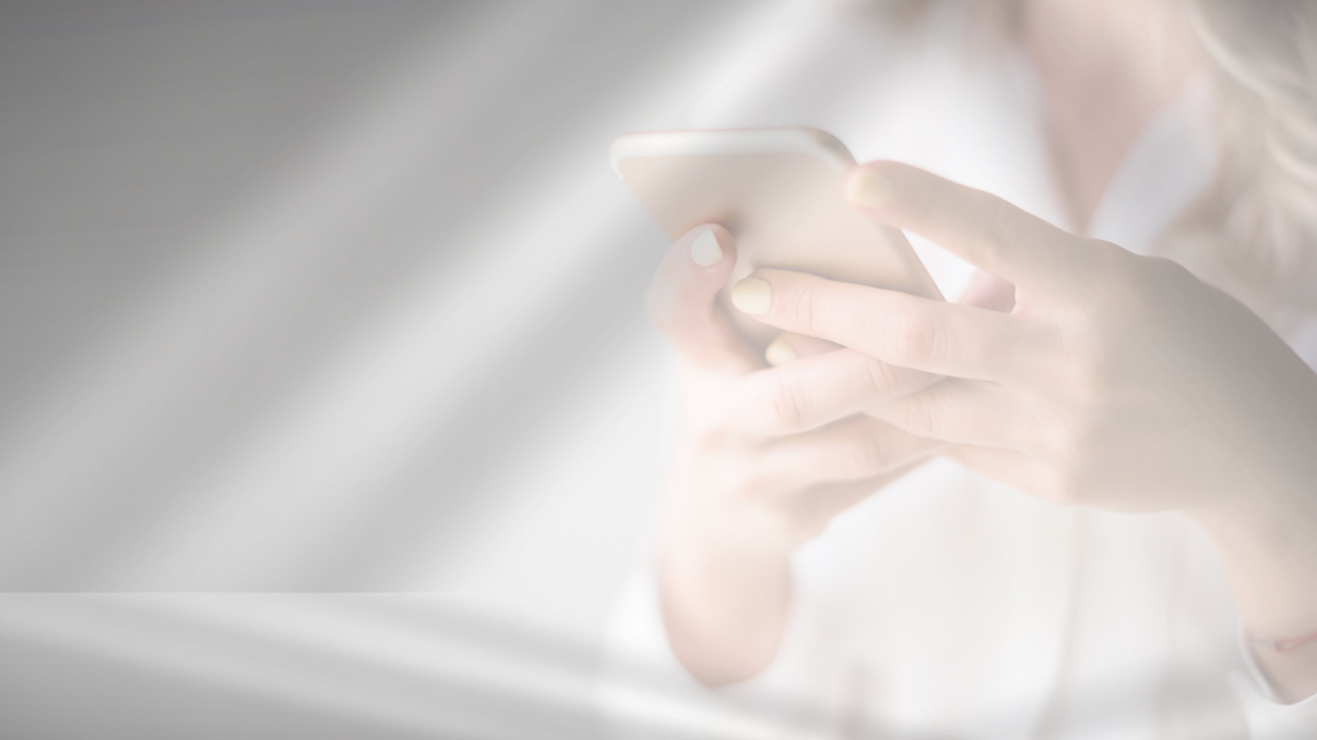Person holding and using a smartphone with a blurred background.
