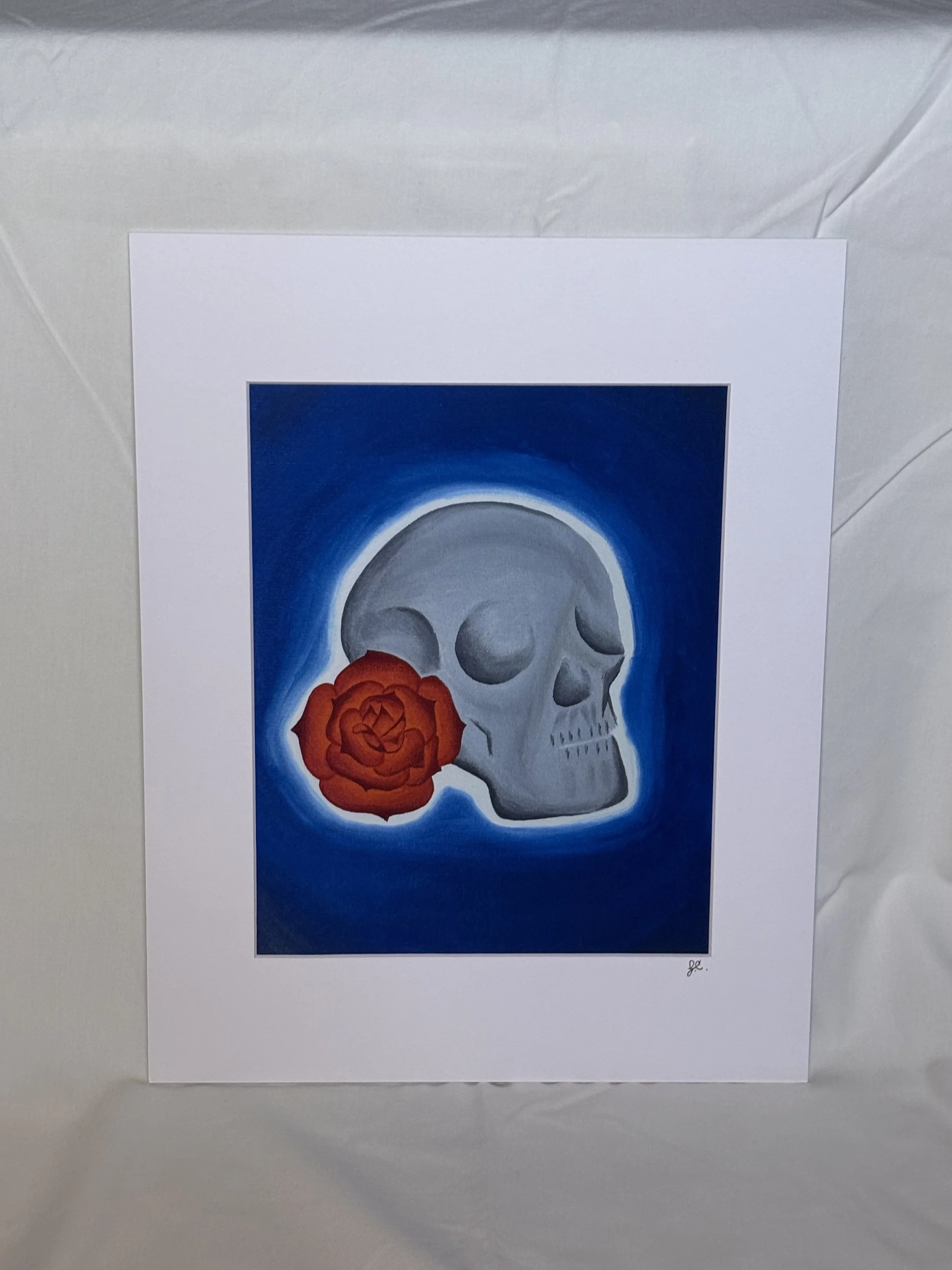 Art print of a skull with a red rose on a blue background with white mat border