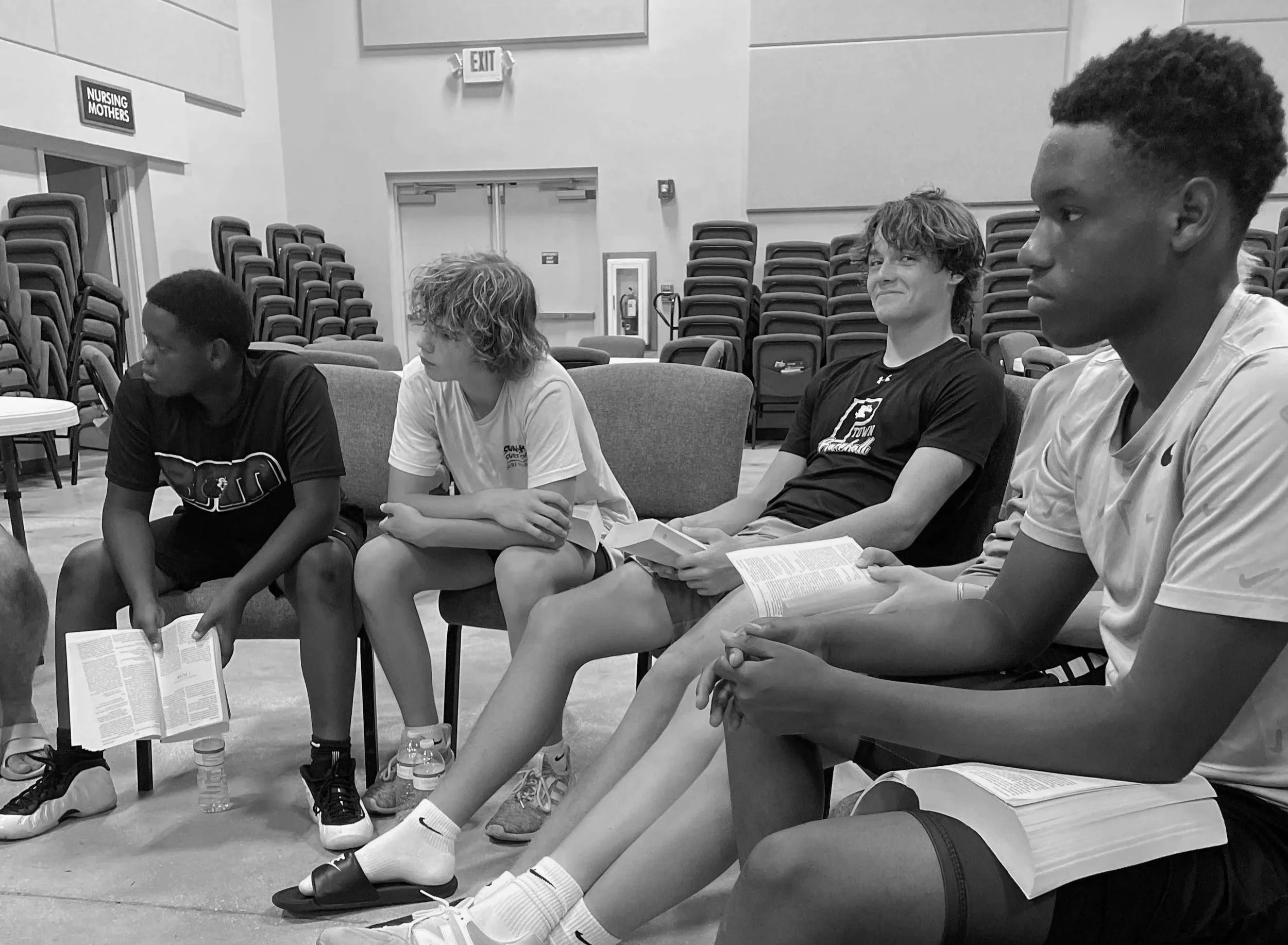 Group of high school and college quarterbacks doing a bible study and engaging in the Bible for a Quarterbacks for Christ event