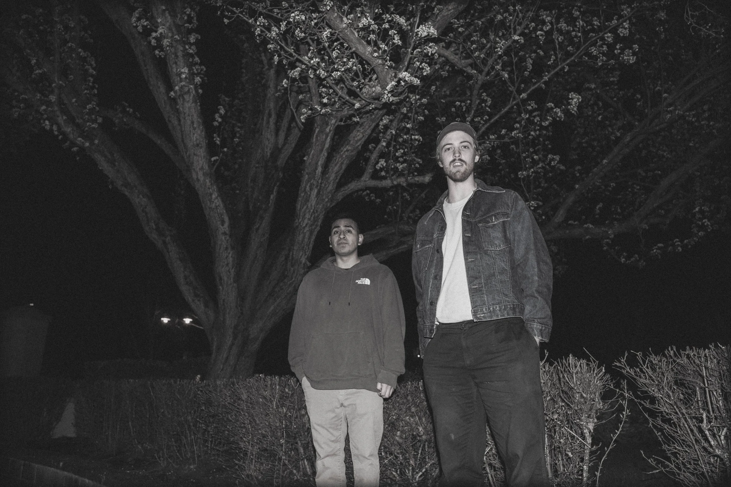 High-contrast candid flash photography of the EL Wedos band in Vancouver, WA. Unpolished style capturing authentic, unfiltered reality and personality against the dark, blooming PNW nature.