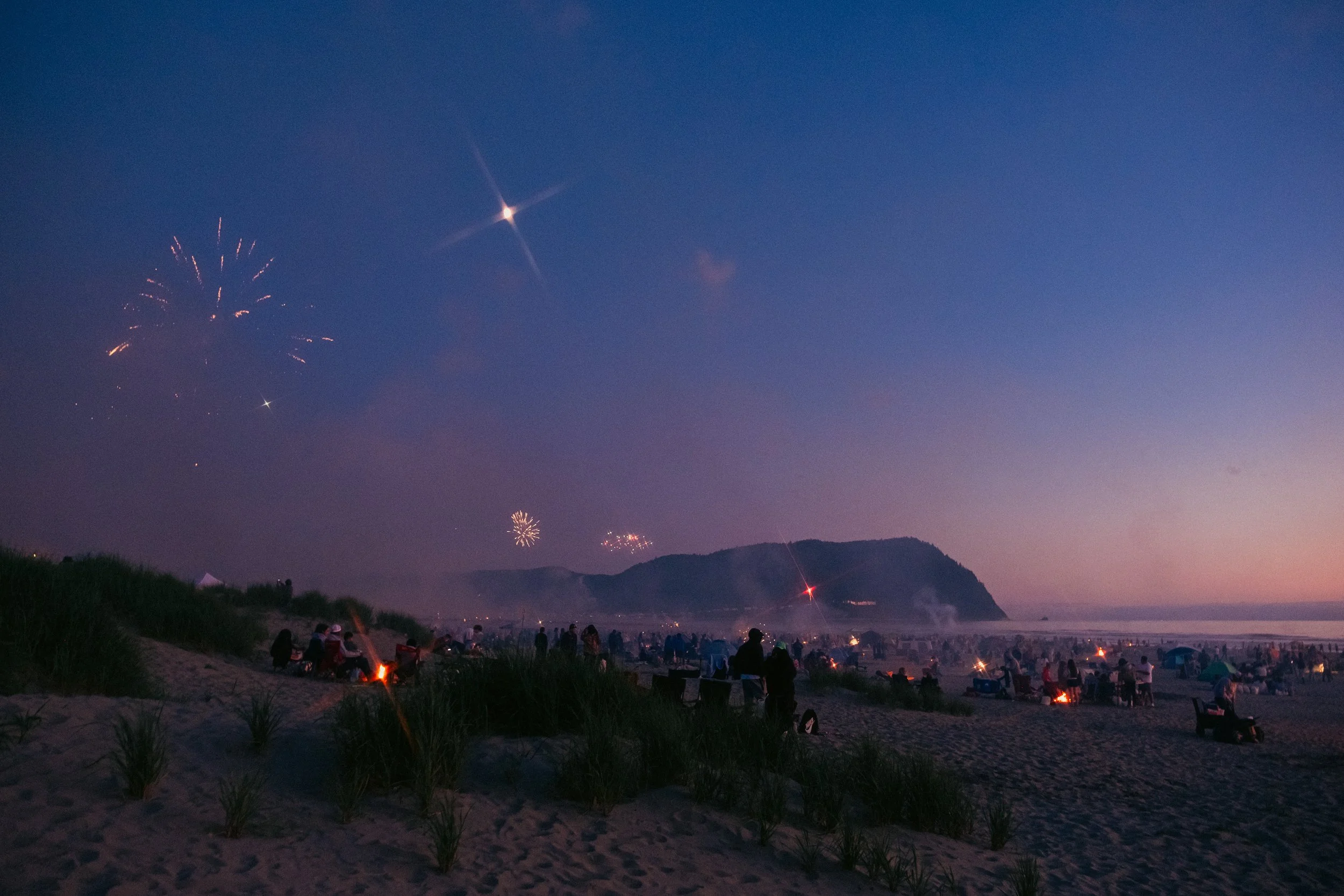 AJ Miranda Long-exposure, cinematic photographs documenting the intense 4th of July fireworks display and grand finale over Seaside, Oregon Coast in 2025. This dark and moody film series captures the chaotic, warzone-like atmosphere of the crowded be
