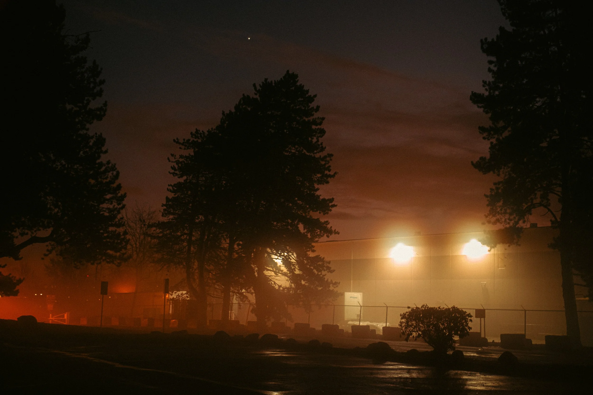 The Night By AJ Miranda Low-light, cinematic photograph of historic Vancouver, WA architecture during blue hour, using ambient light and deep chiaroscuro shadows to create an eerie film aesthetic.