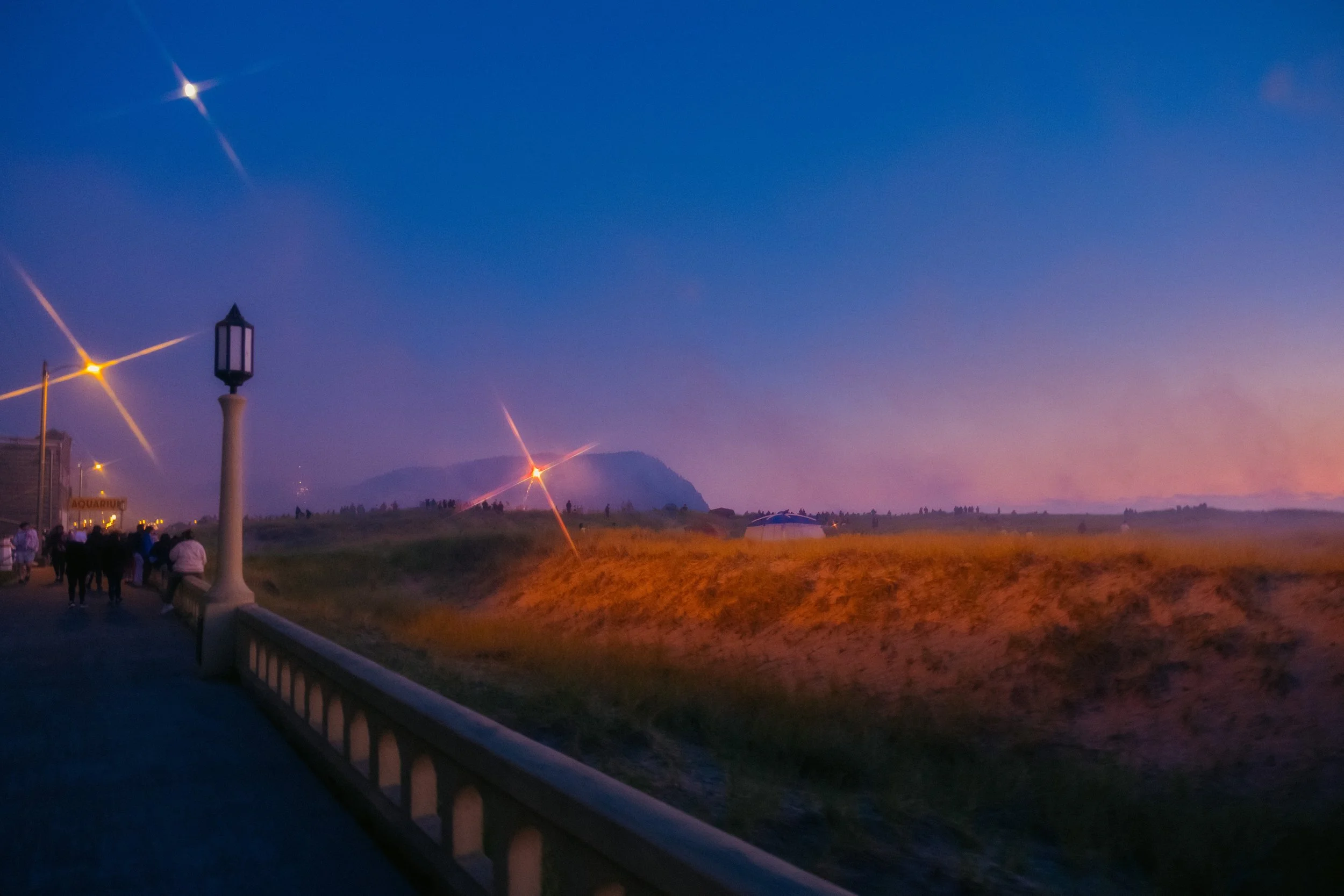AJ Miranda Long-exposure, cinematic photographs documenting the intense 4th of July fireworks display and grand finale over Seaside, Oregon Coast in 2025. This dark and moody film series captures the chaotic, warzone-like atmosphere of the crowded be