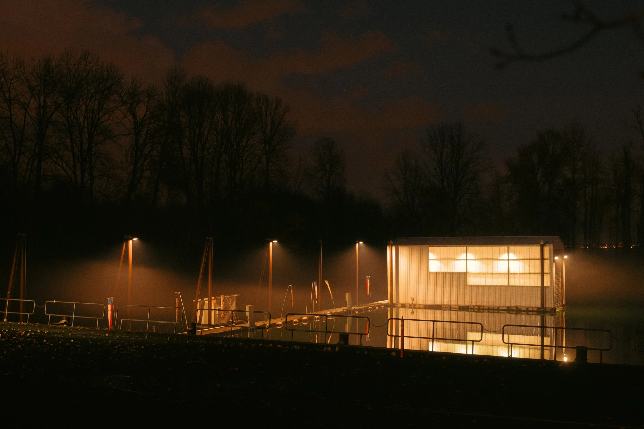 The Night By AJ Miranda Low-light, cinematic photograph of historic Vancouver, WA architecture during blue hour, using ambient light and deep chiaroscuro shadows to create an eerie film aesthetic.