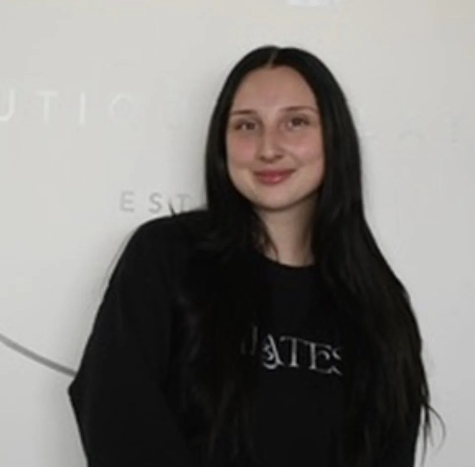 A young girl with dark hair smiling