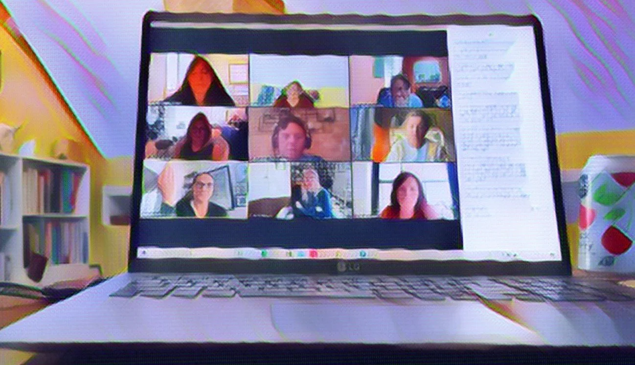 Evangeline Weiss Consulting | Laptop screen showing a virtual meeting with nine participants in a grid view, with other items like a bookshelf and a paper cup nearby.