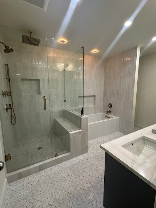 Bathroom with walk-in shower, bathtub, and vanity with sink.