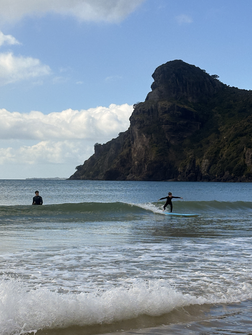 A young surfer riding a wave at Taupō Bay