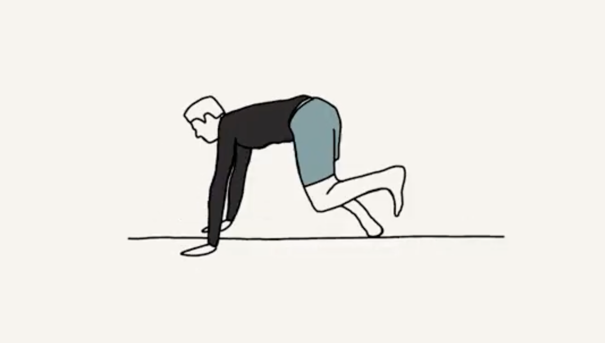 A person in a black long-sleeve shirt and blue shorts is on all fours, with their hands and feet on the ground in a crawling position.