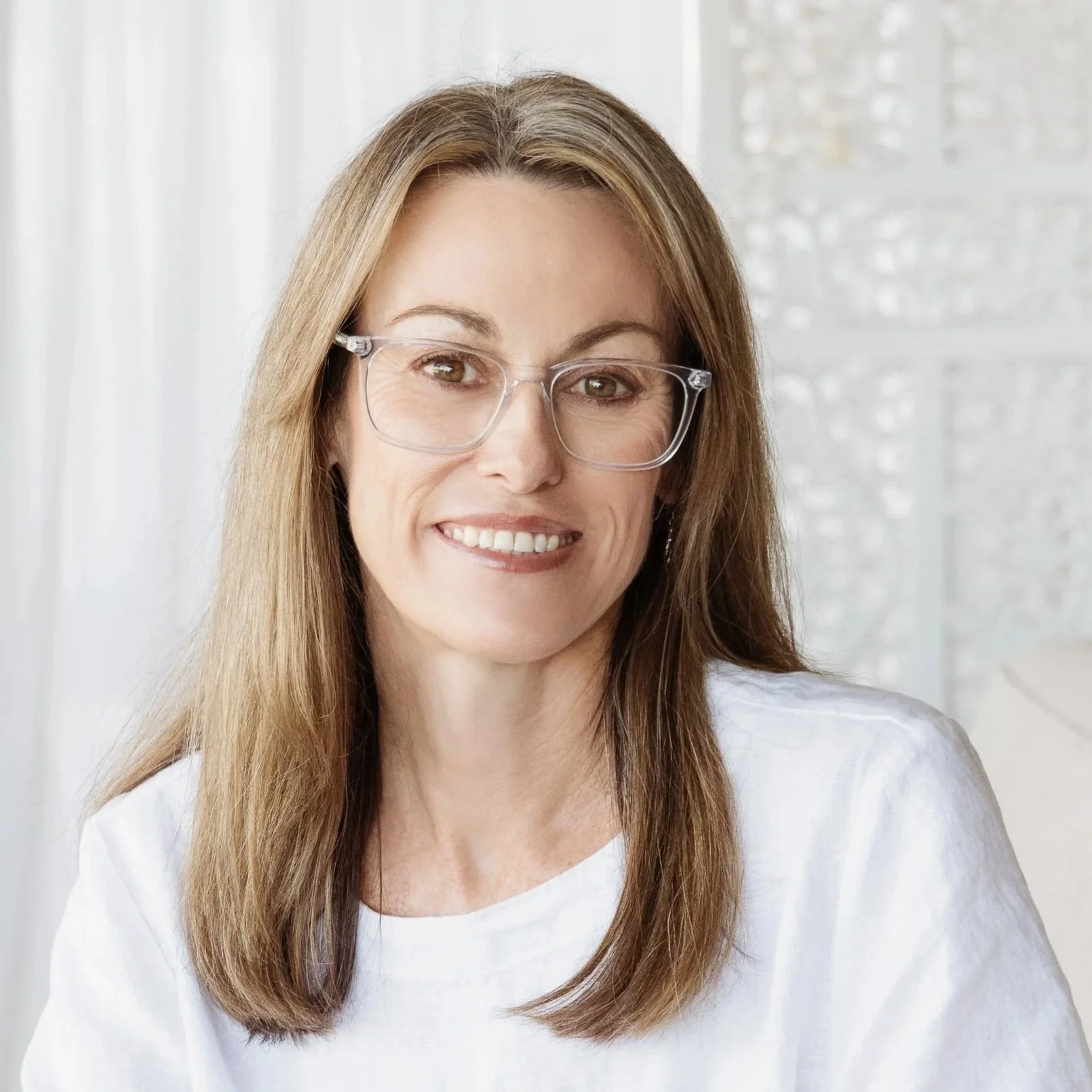 Lisa Proctor, long brown hair, clear glasses, white top, close‑up smile – Blue Sky Planning & Environment town‑planning.